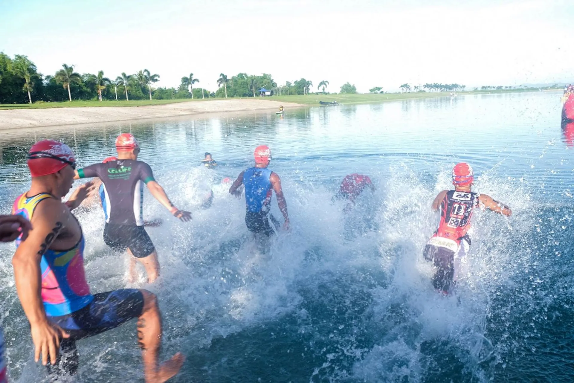 The image shows a group of people, most likely triathletes, at the