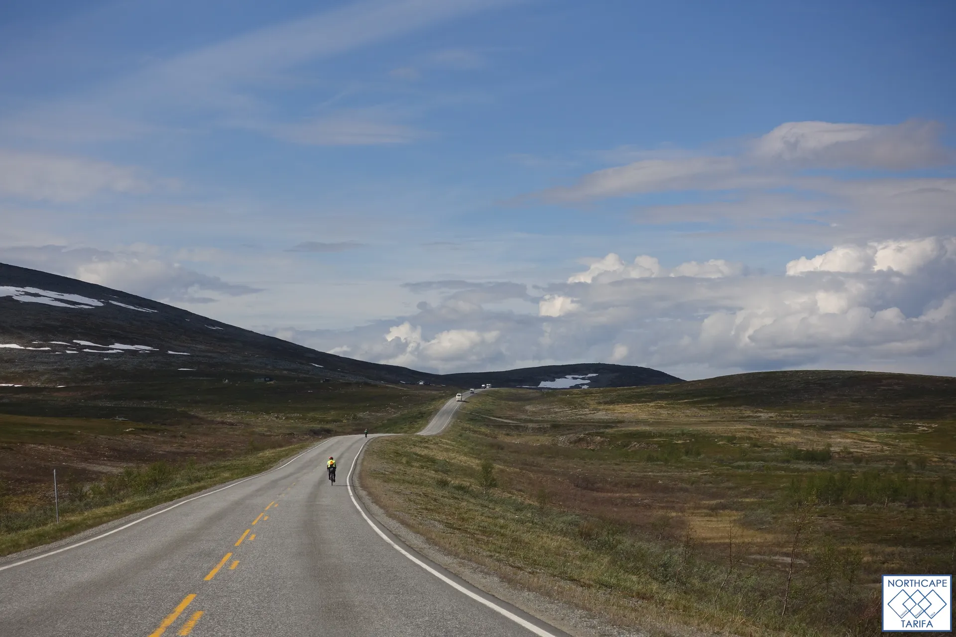 The image shows an expansive landscape with a road extending into the distance, cutting through