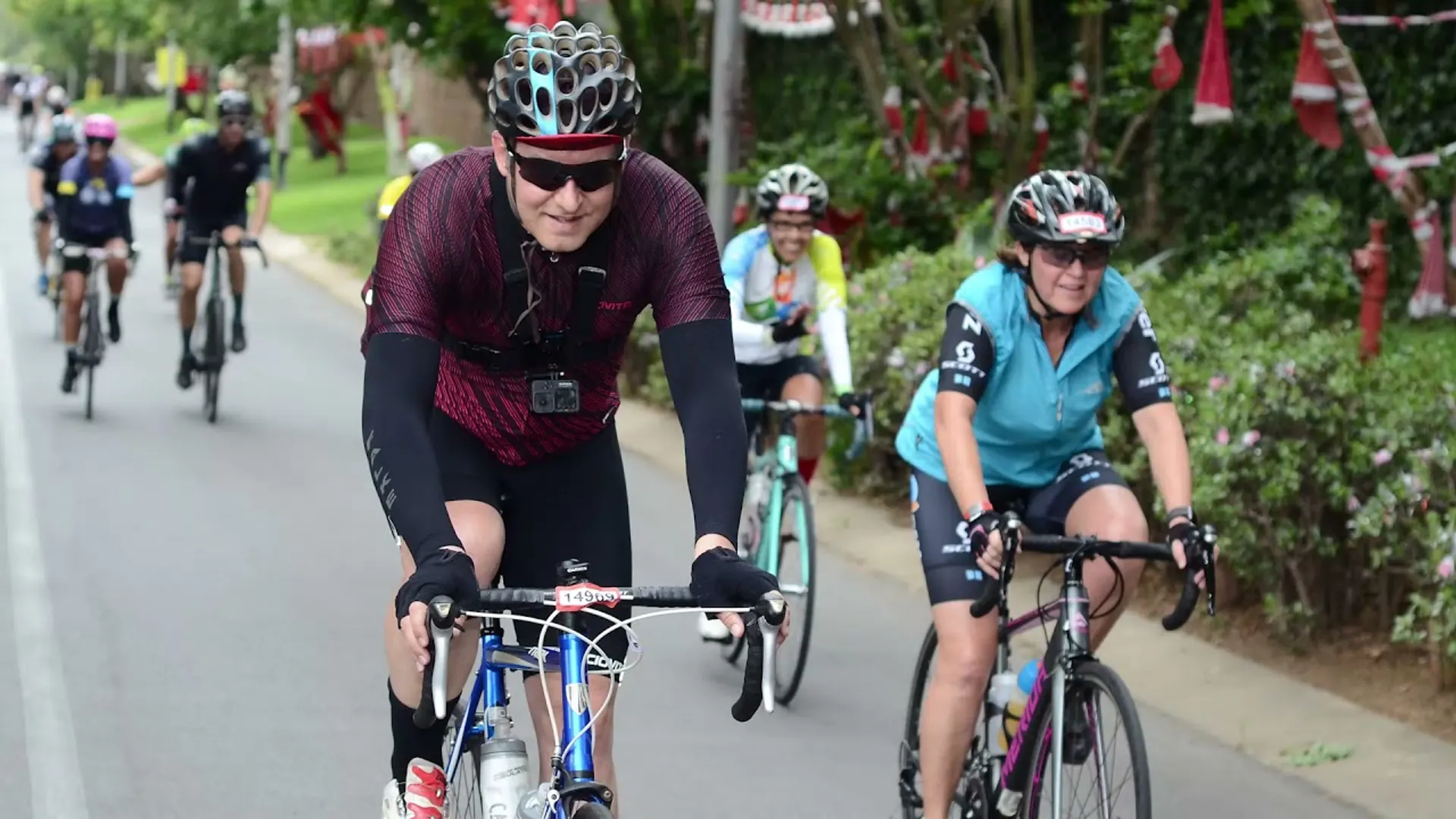 This image depicts a group of cyclists riding on a road. The cyclist in the