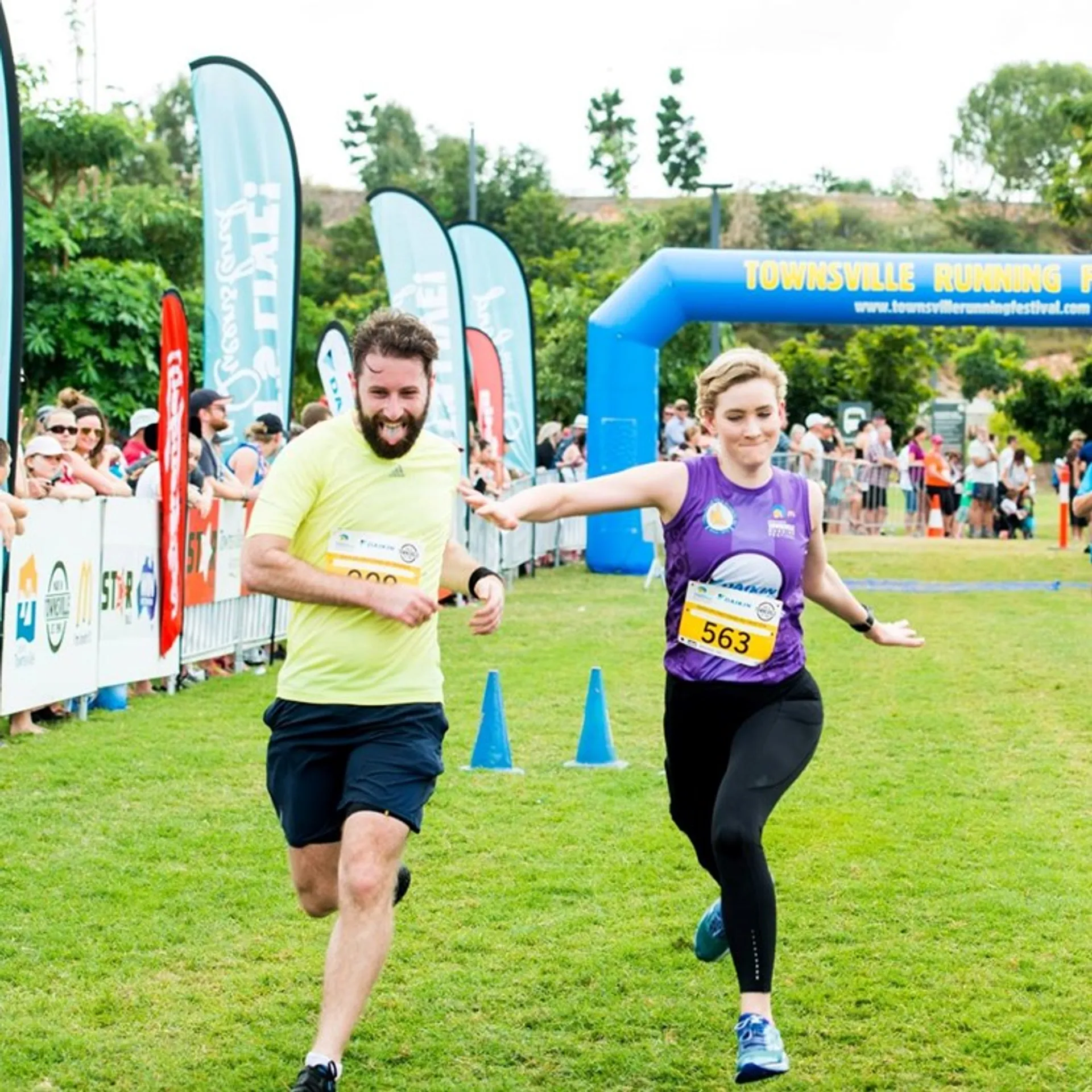 This is an image of two runners crossing the finish line at a running event,