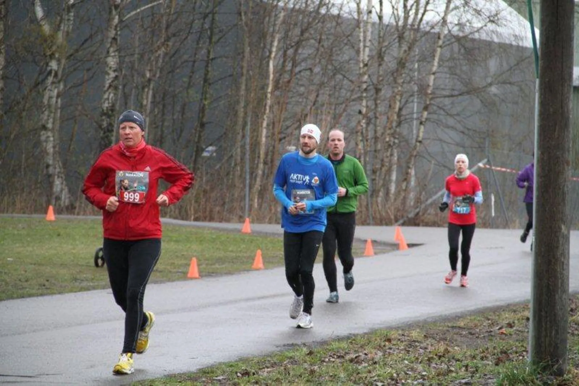 The image depicts a group of people participating in a running event. They appear to
