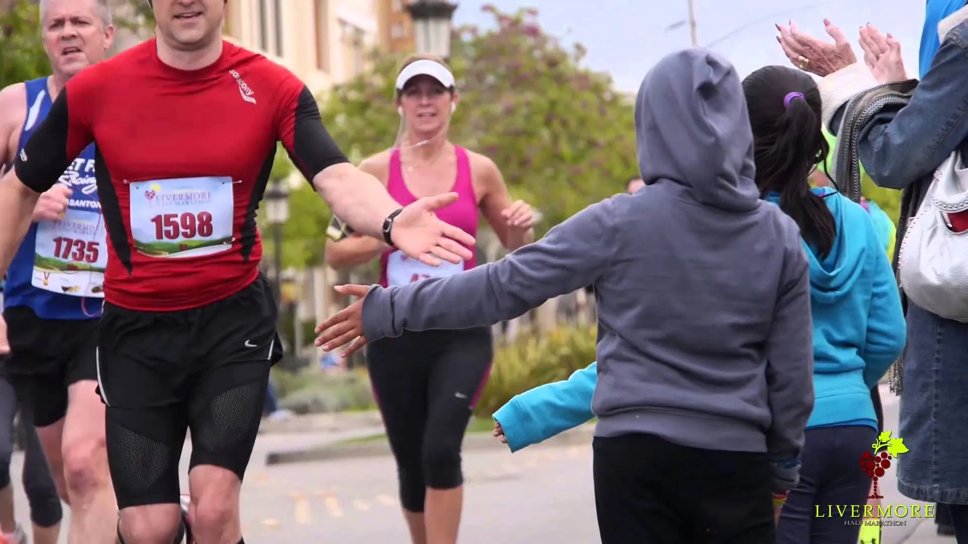 The image depicts a road running event, likely a marathon or a race, where