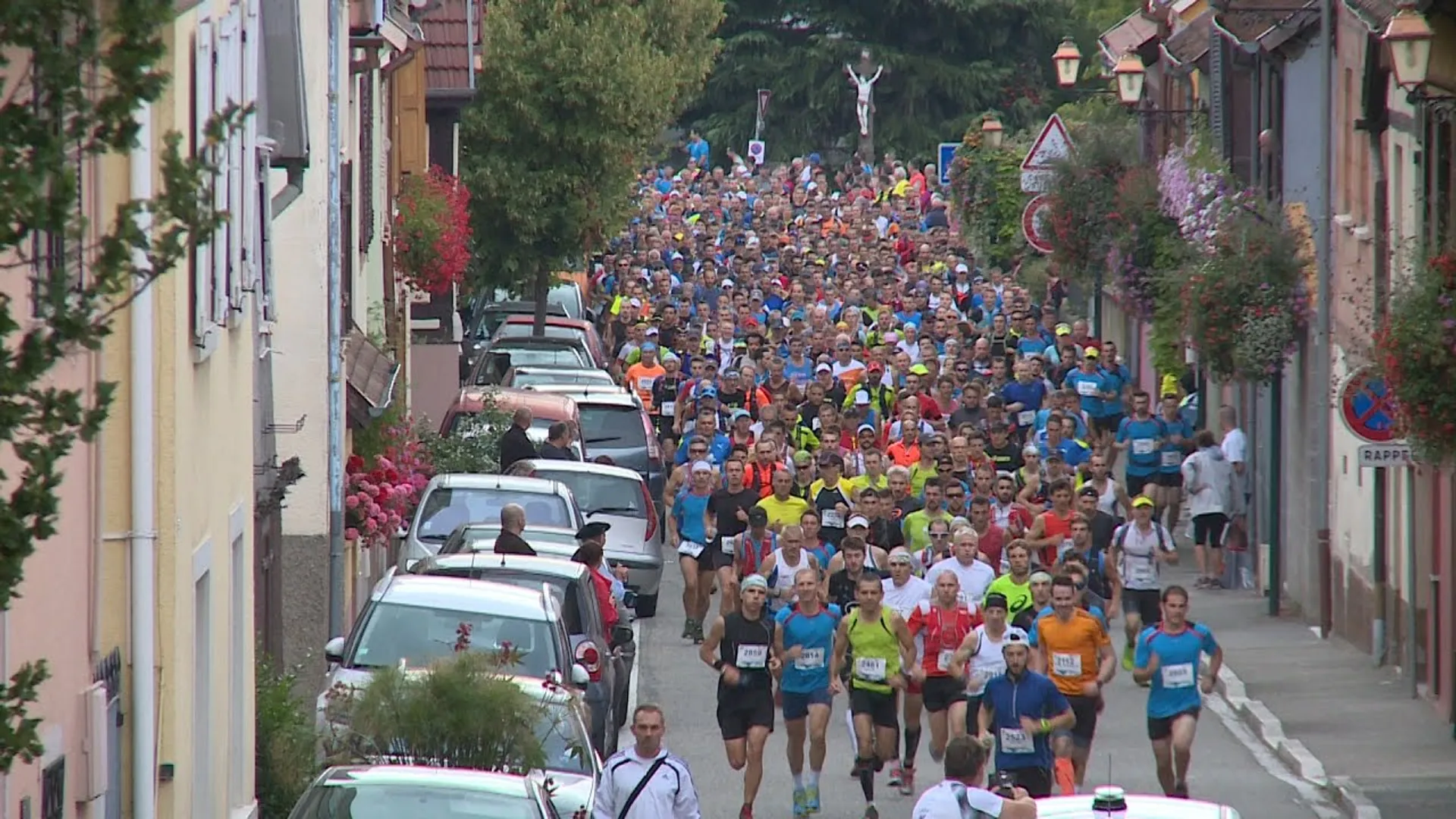 The image shows a large group of people participating in a running event, probably a