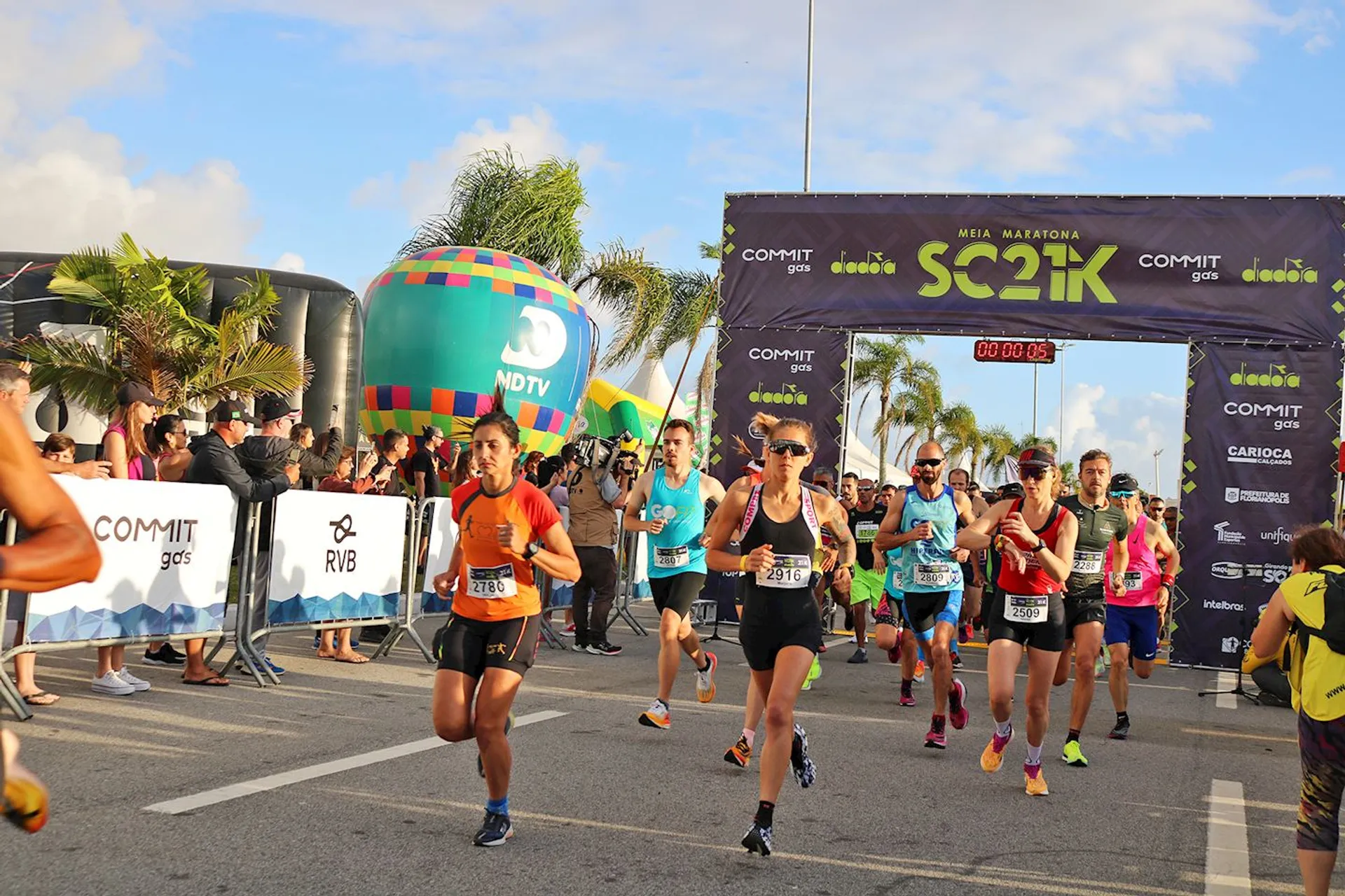 This is an image of a road race event. We can see runners crossing the