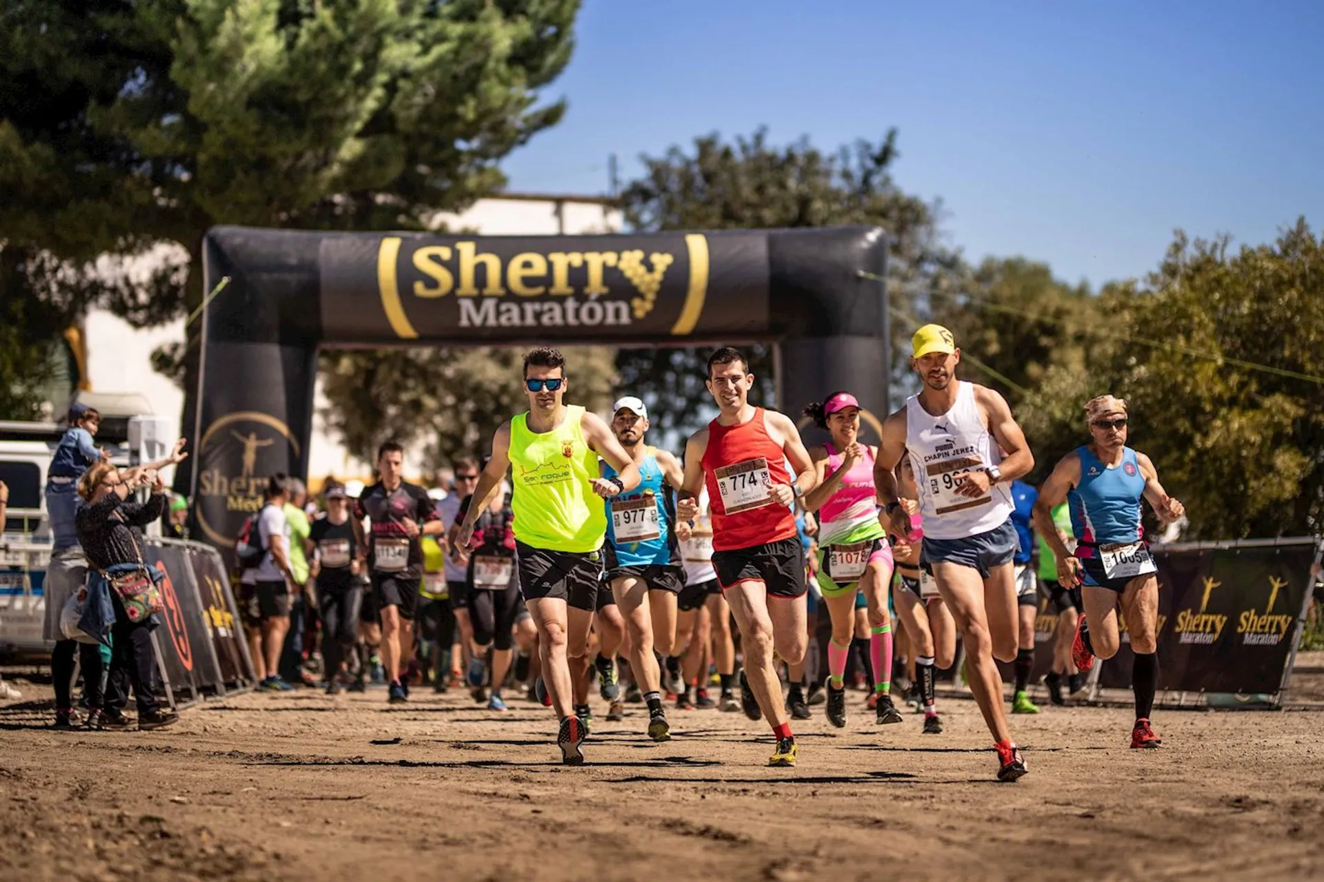 The image shows a group of runners at the start of a race, probably a