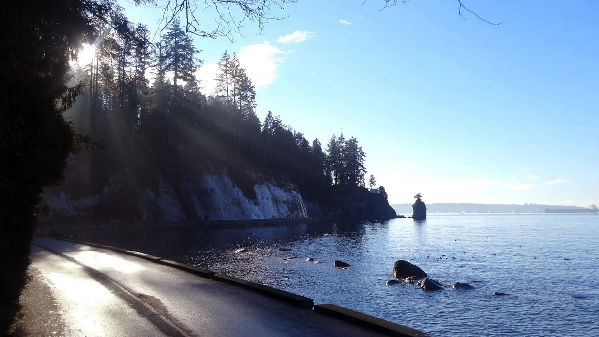 The image shows a beautiful scenic view with sunlight filtering through the trees, creating a