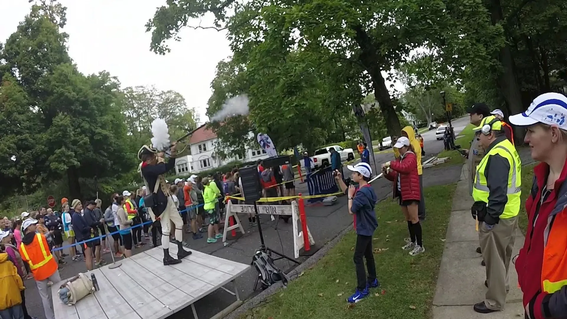 The image shows a group of people outdoors witnessing an apparent demonstration or an event.