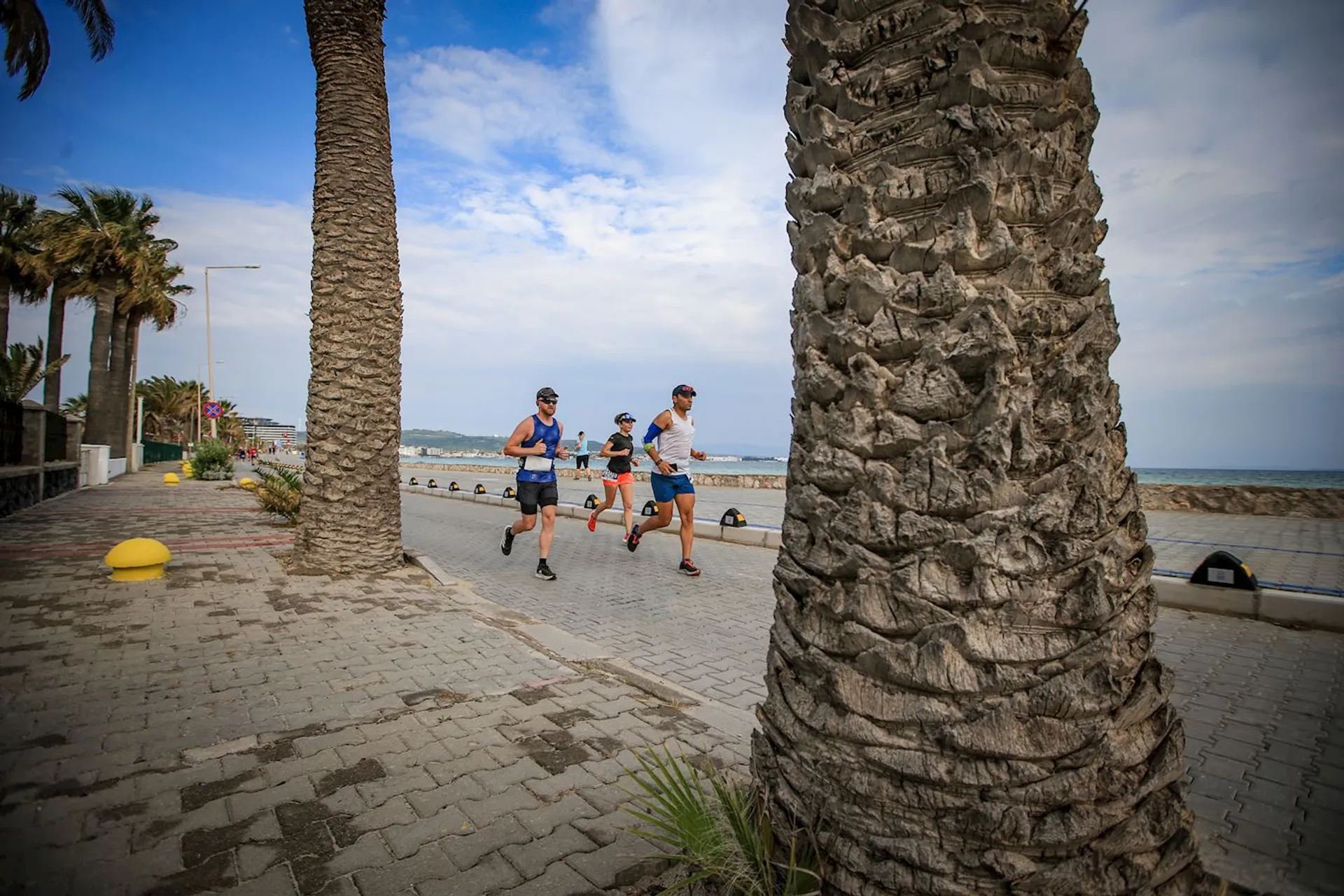 The image shows three individuals who appear to be engaged in running or jogging along a