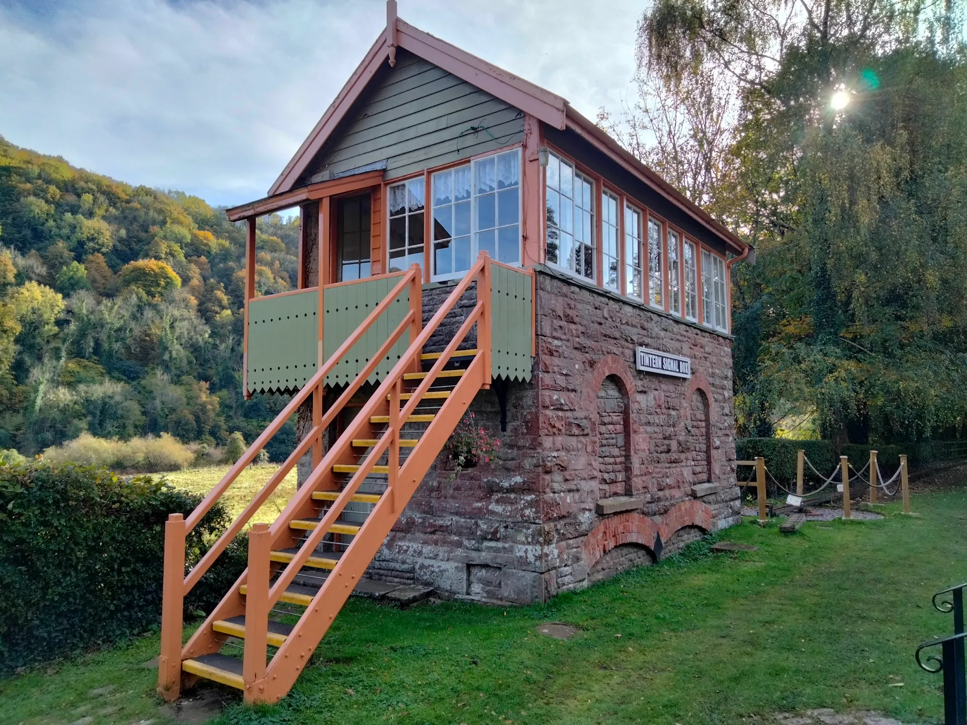 The image shows a quaint, small building constructed with a combination of brick or stone