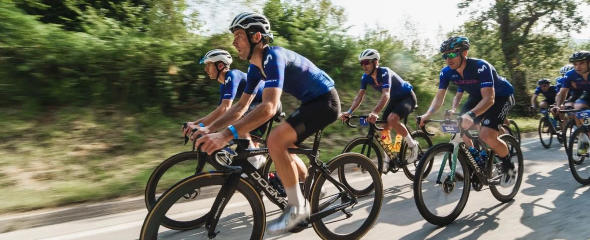 The image shows a group of cyclists riding their bikes at what appears to be a