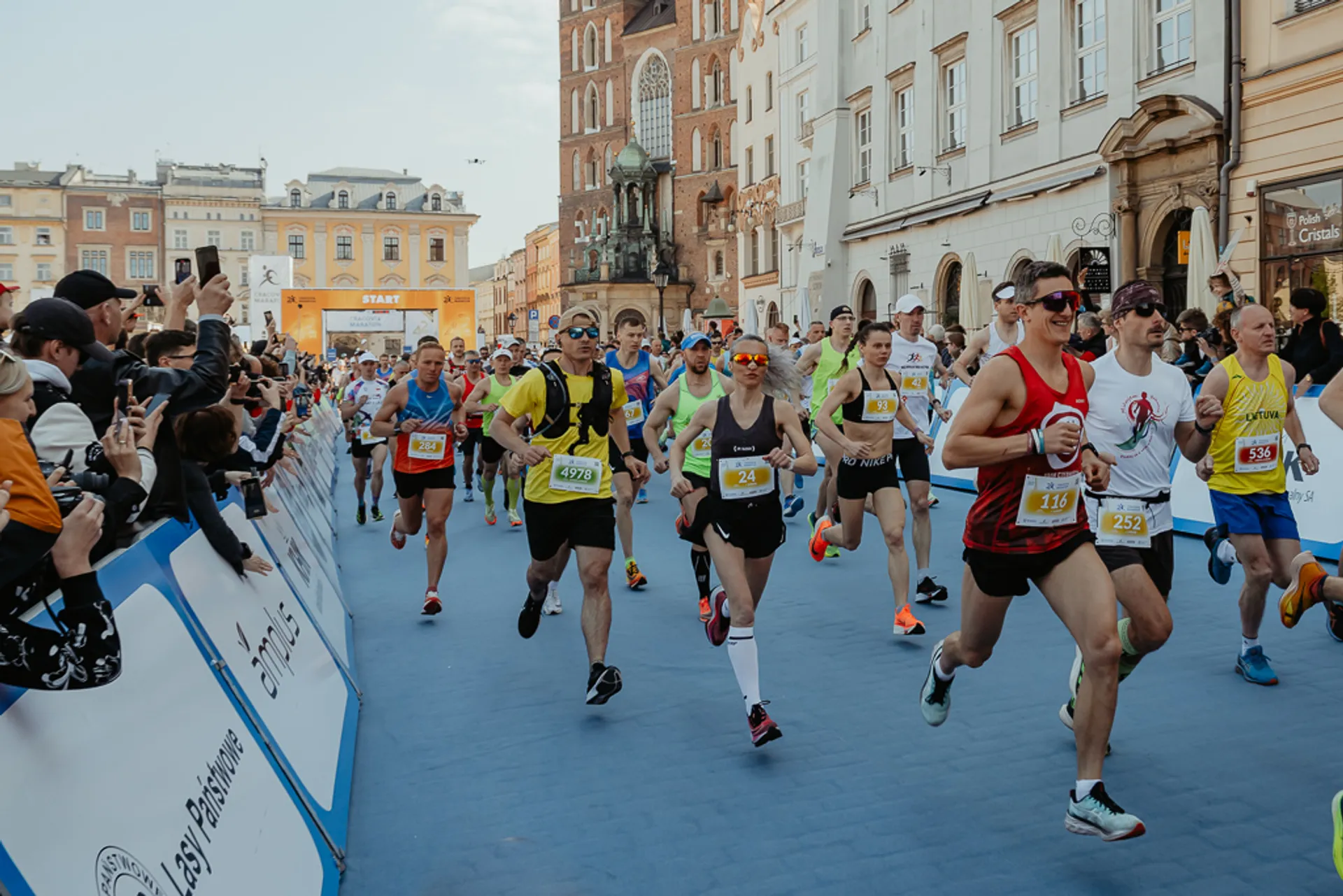 The image shows a group of runners participating in a road race. They appear energetic