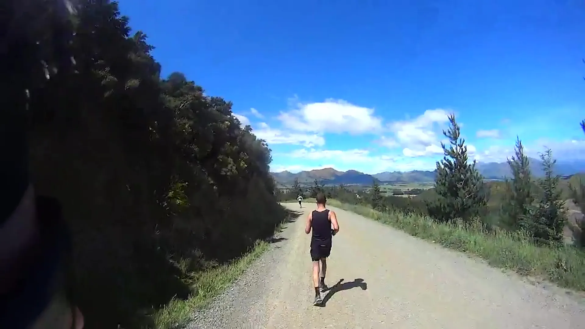 The image shows a person from behind, who appears to be running or walking along