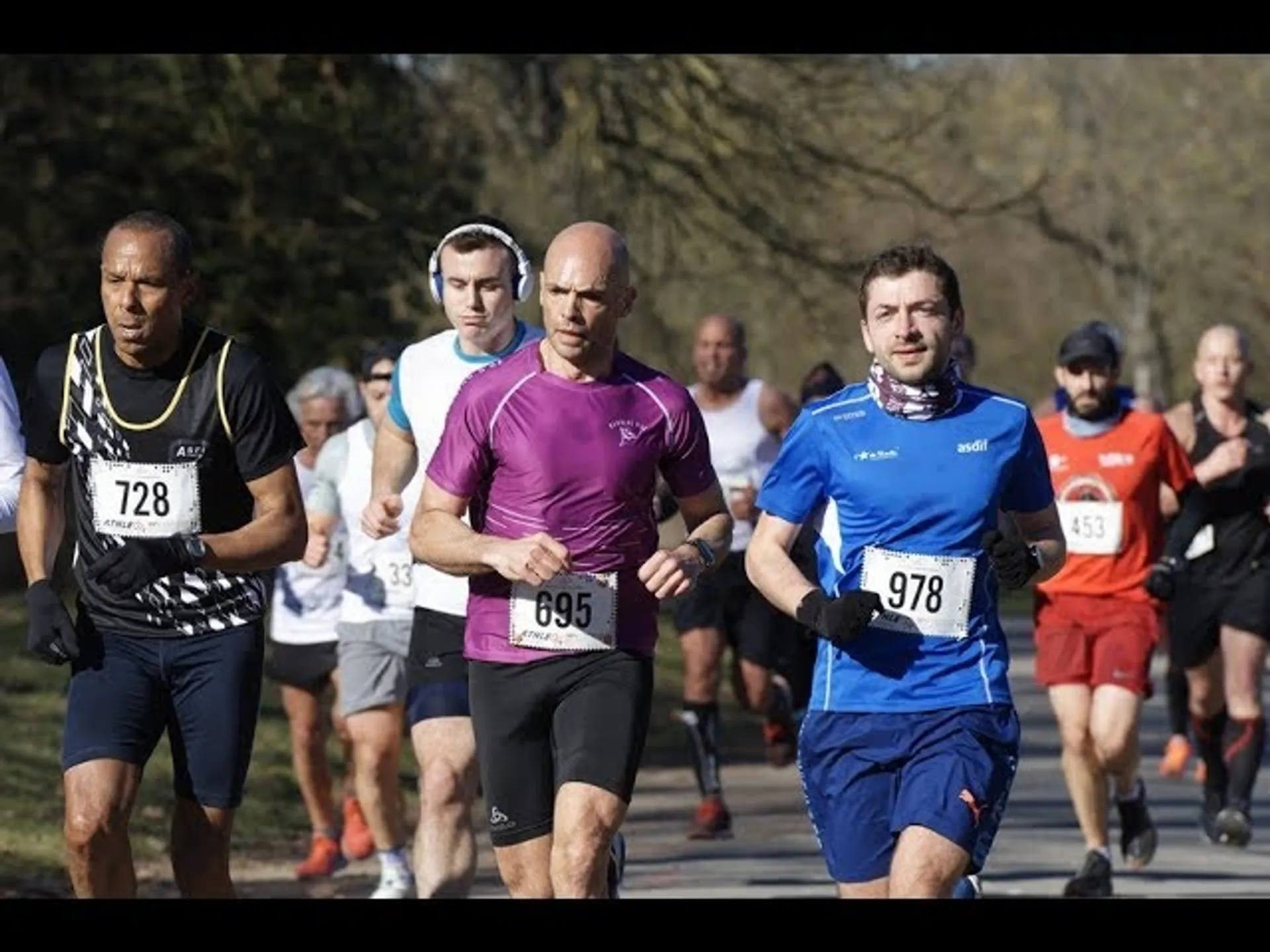 The image shows a group of runners participating in a race or a running event.
