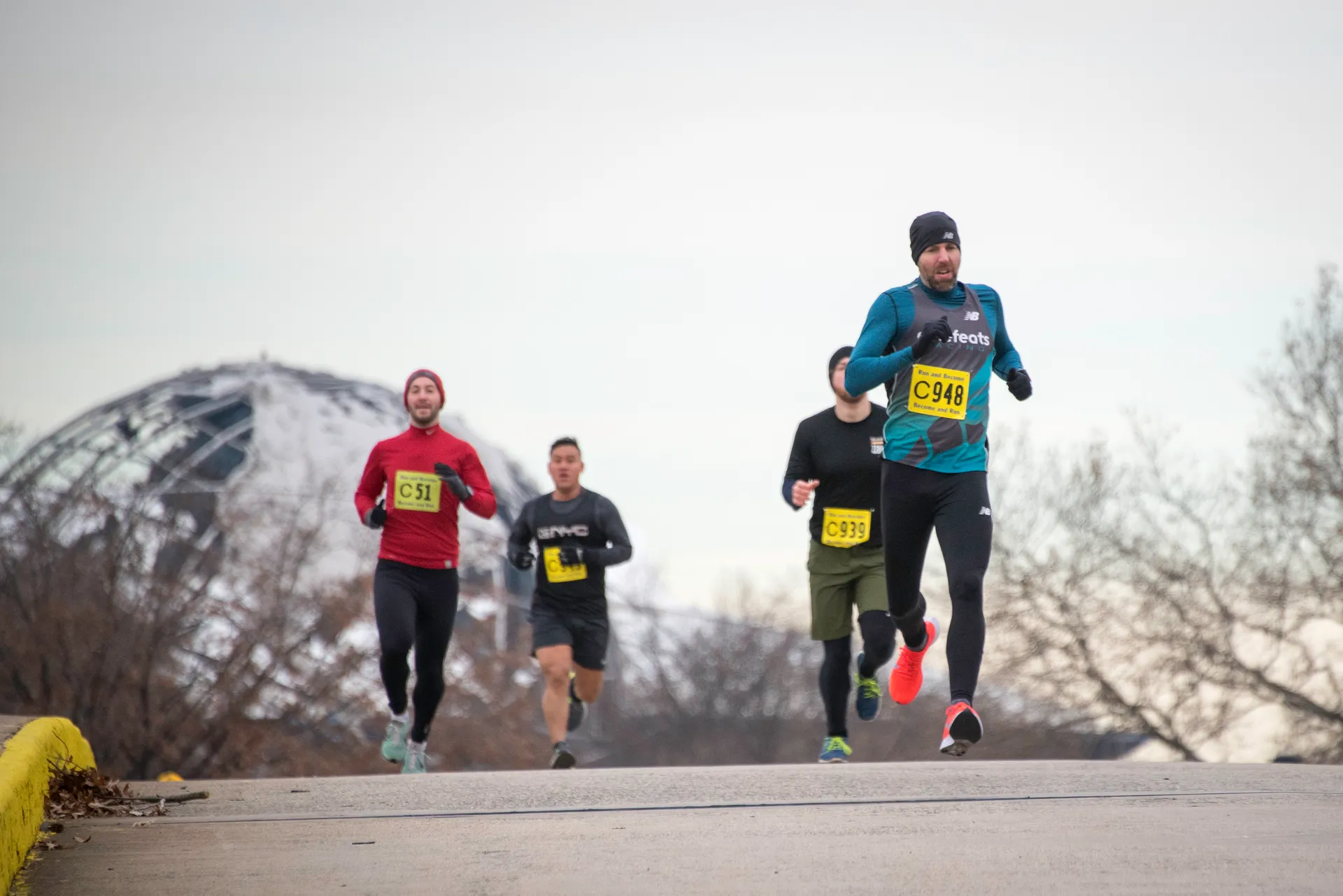 The image shows a group of runners participating in a road race. They are wearing