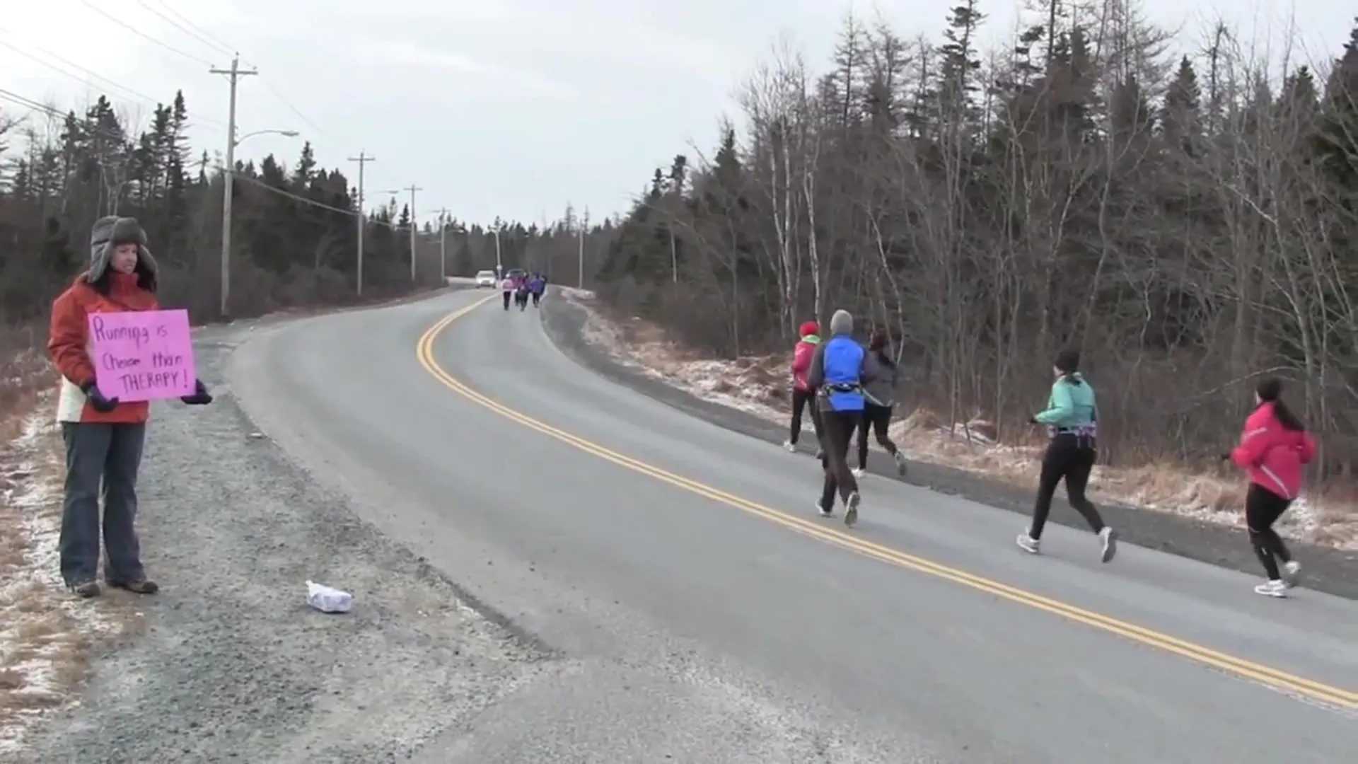 The image shows a group of people participating in an outdoor running event or marathon.