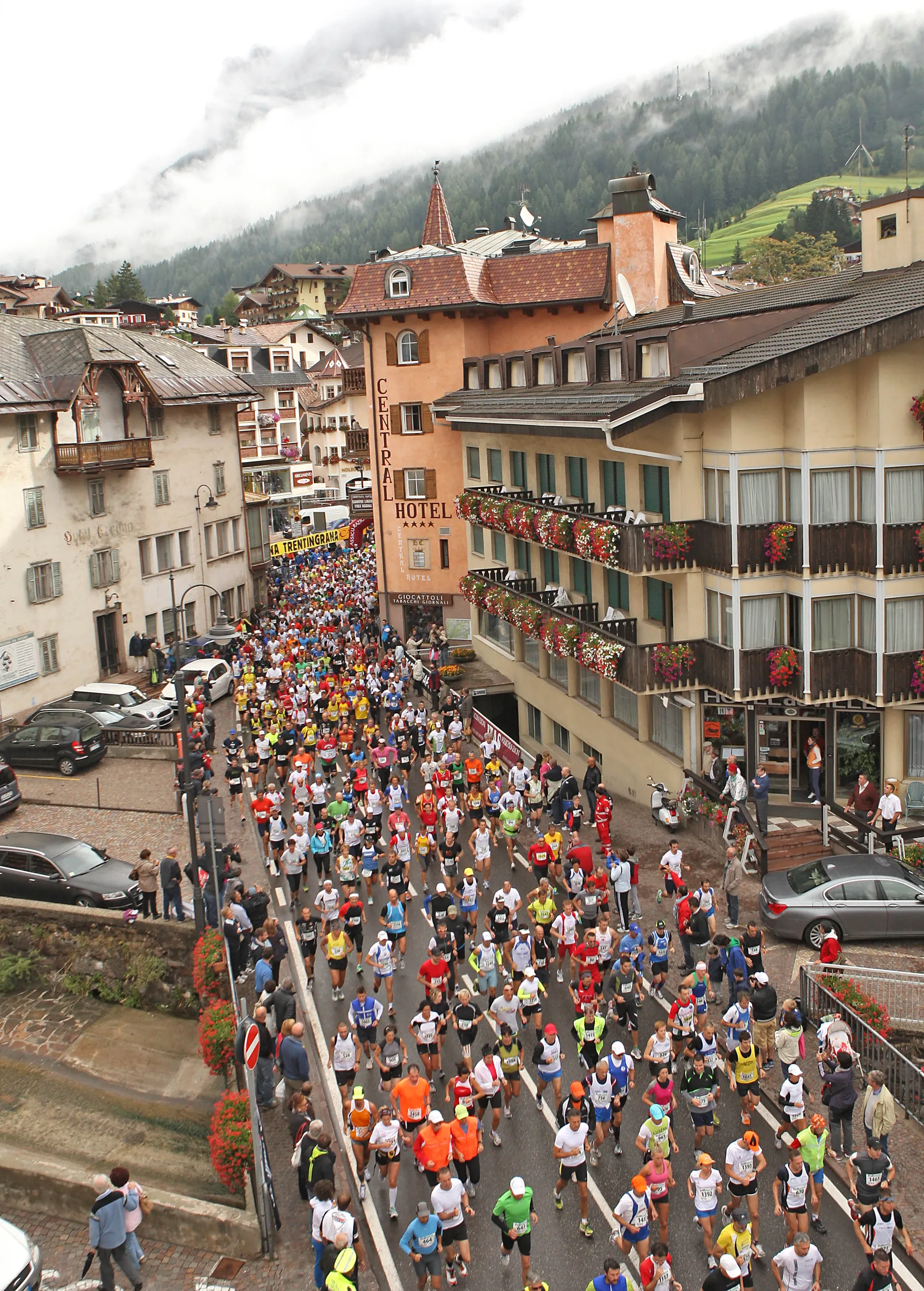 This image features a large group of runners participating in a road race through a town
