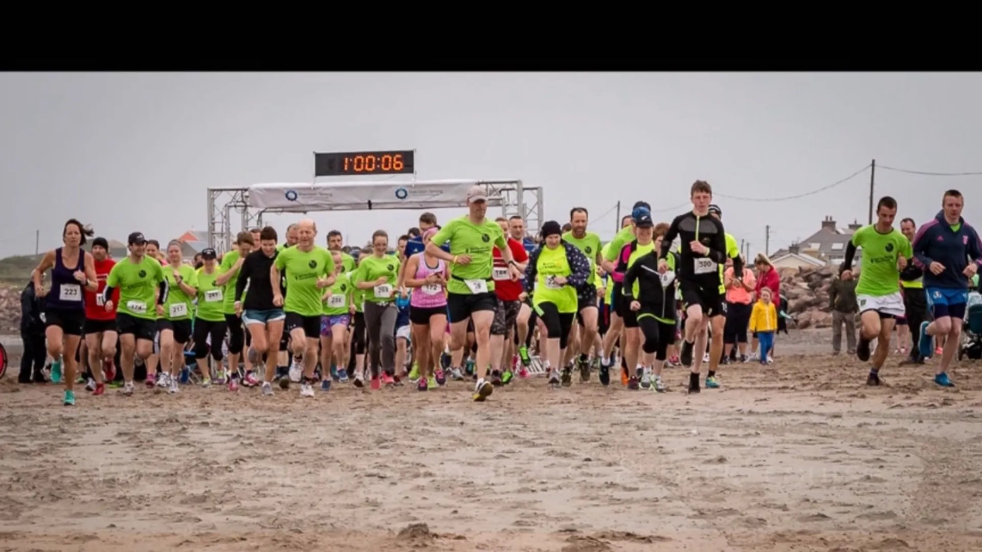 The image shows a group of people participating in a running event or race. They