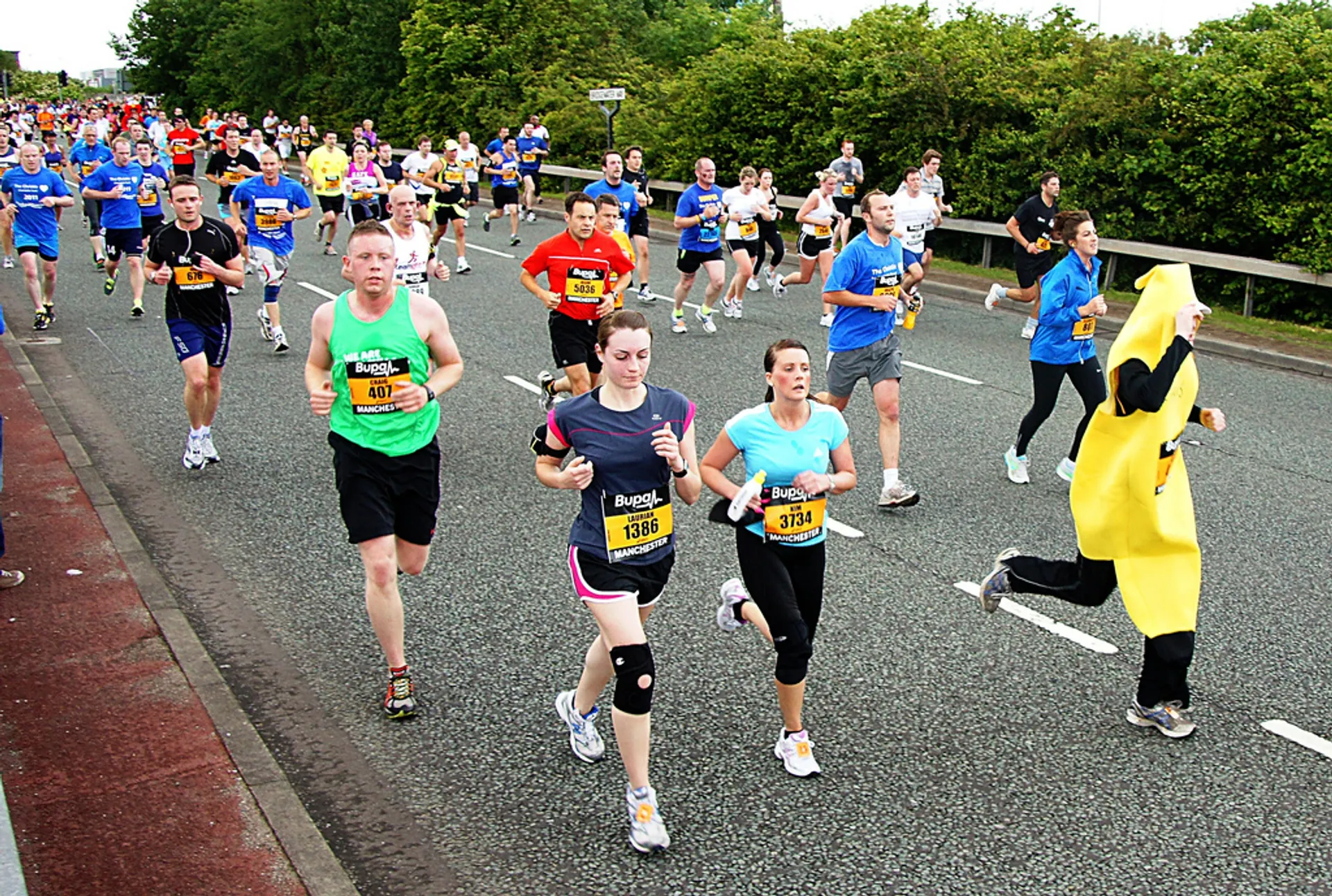 The image depicts a group of people participating in a running event or marathon. In