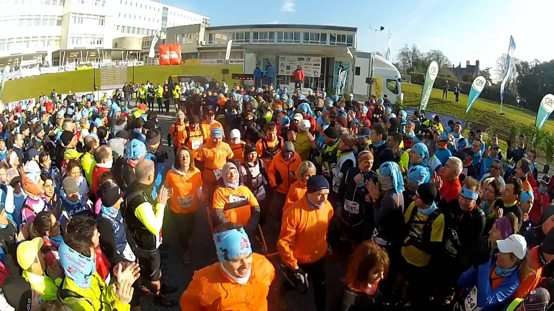 The image shows a large group of people gathered for what appears to be a running