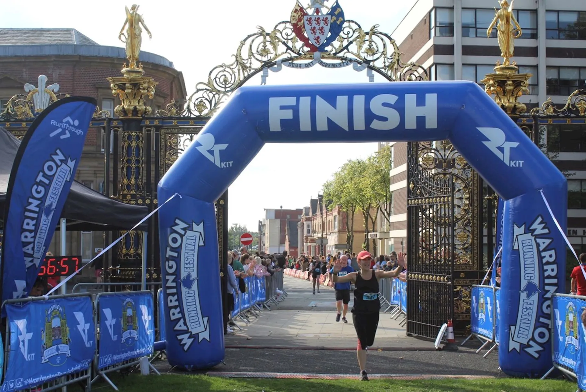 The image shows a finish line arch at the end of a race event. The
