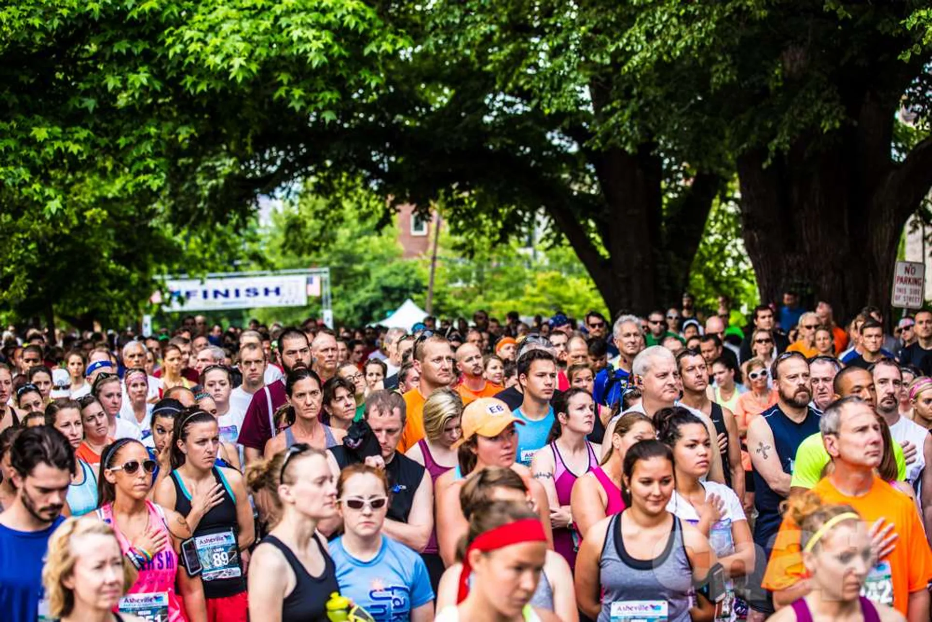 The image shows a large group of runners gathered at the starting line of a race