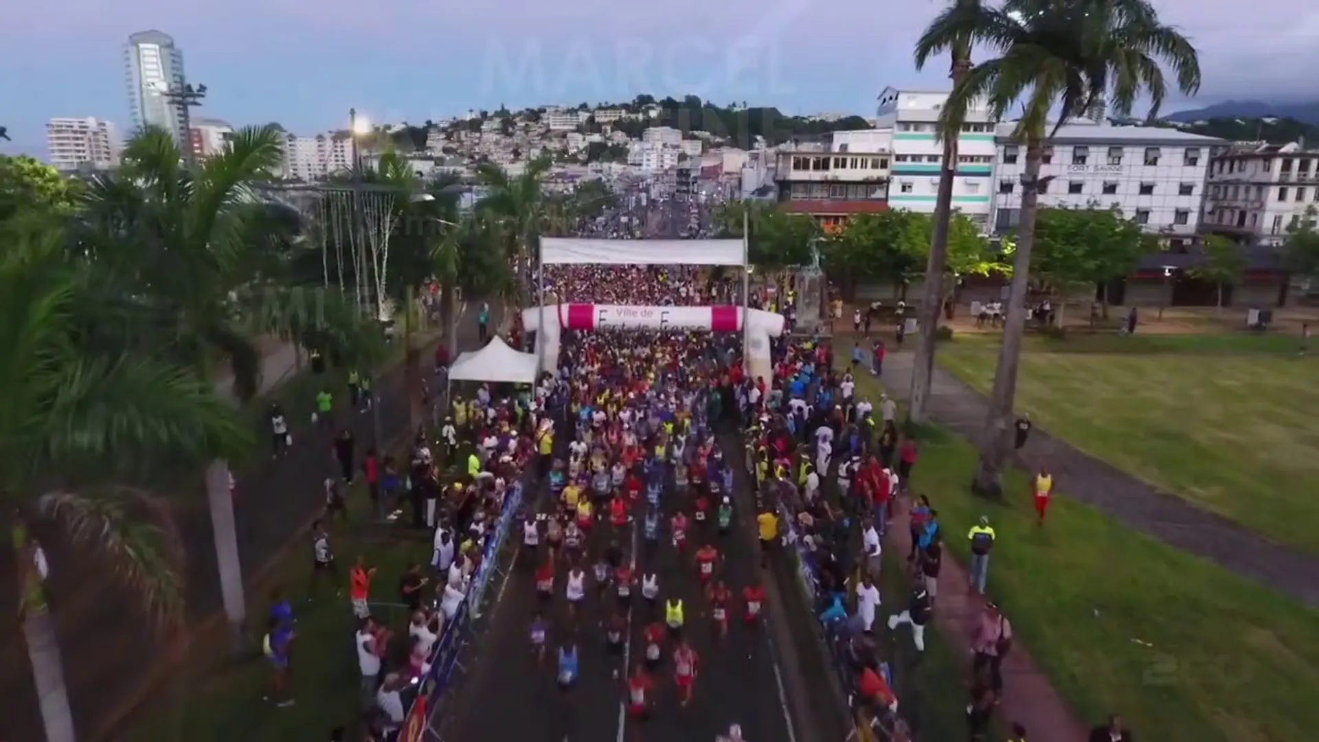 The image shows a large group of people at what appears to be a starting line