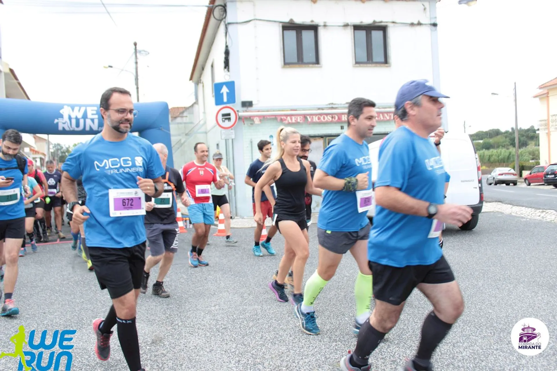 The image shows a group of runners participating in a road race. They appear to