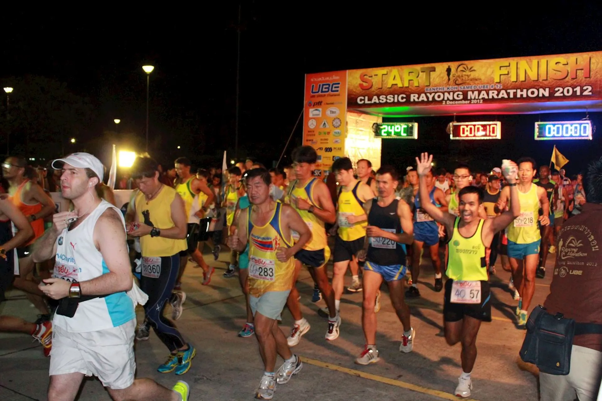 This image shows a group of runners participating in a marathon event at night. They