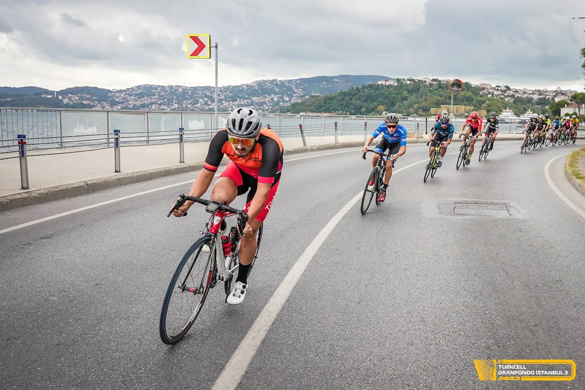 In the image, we see a group of cyclists participating in a road cycling race