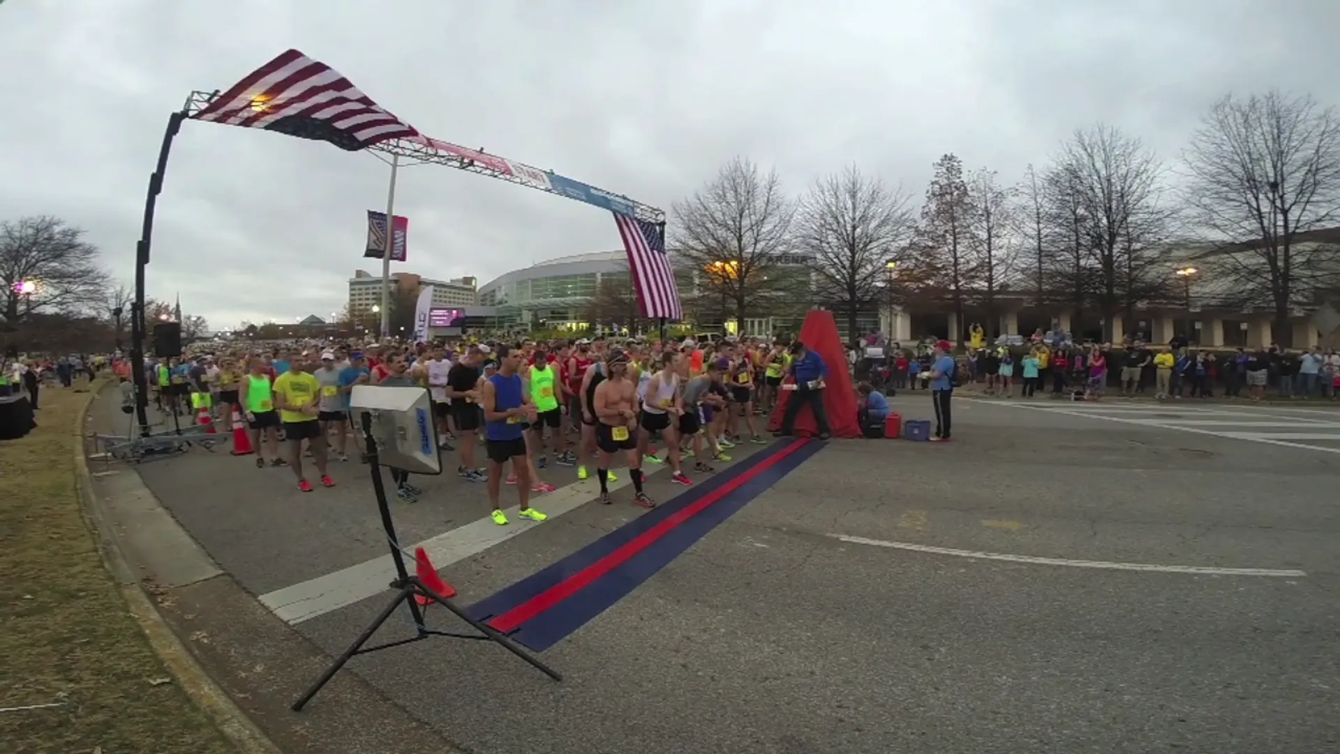 This image shows a group of runners at the start line of a running event,