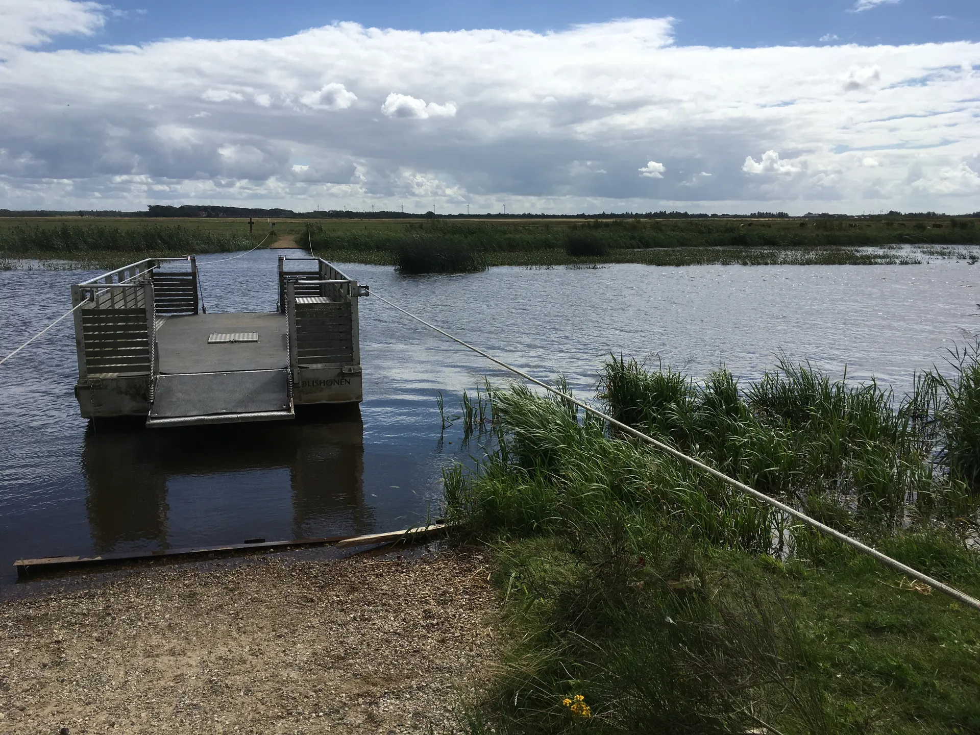 The image depicts a tranquil outdoor scene with a body of water, possibly a lake