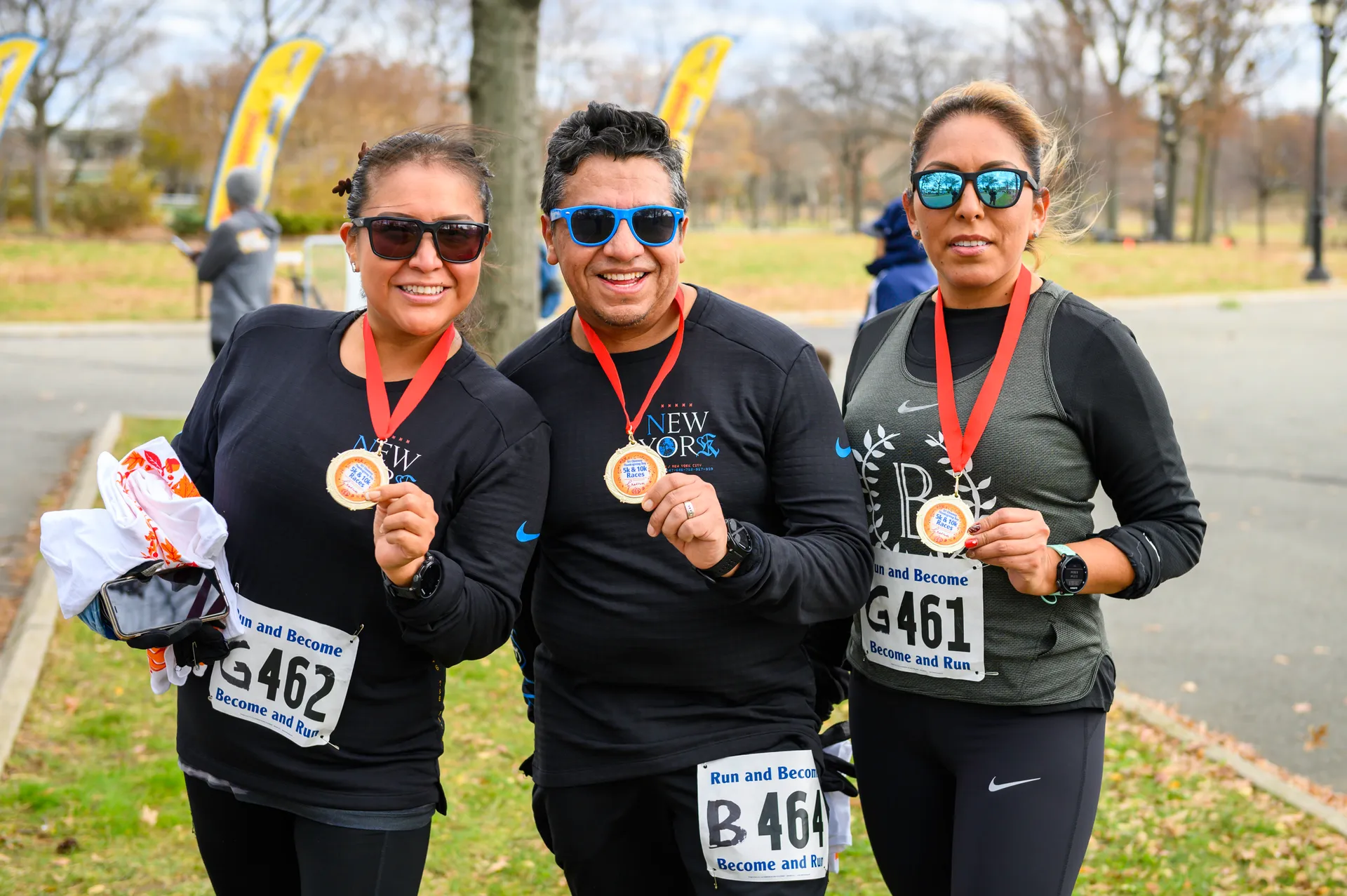 In the image, there are three people standing outdoors, likely in a park or