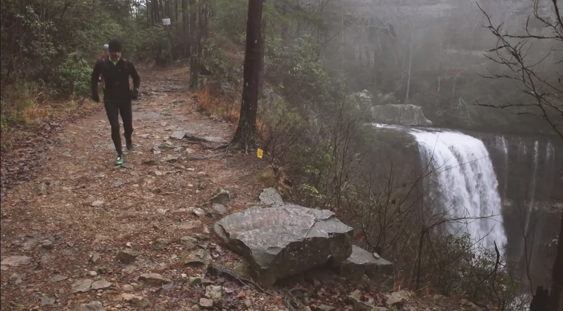 The image shows a person jogging on a trail. The trail appears to be a