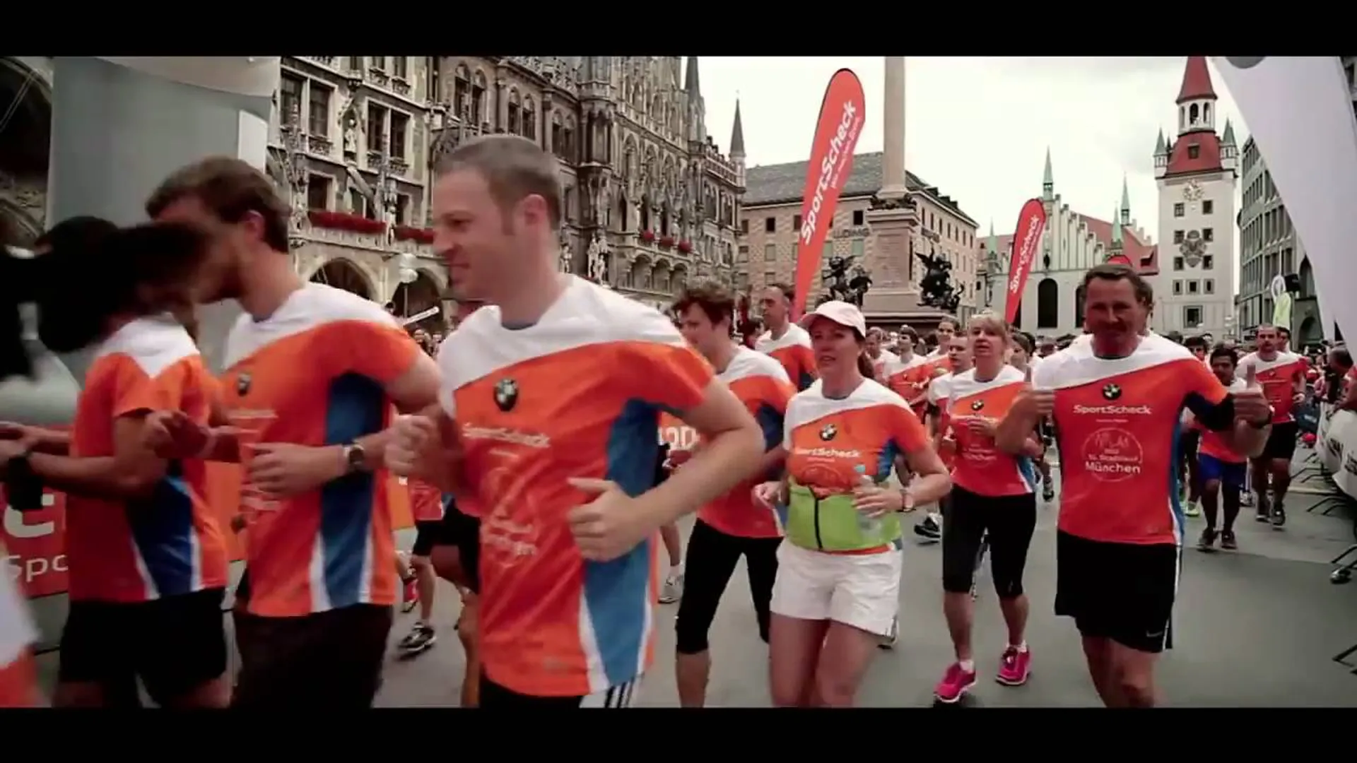 The image shows a group of people participating in a running event. They are wearing
