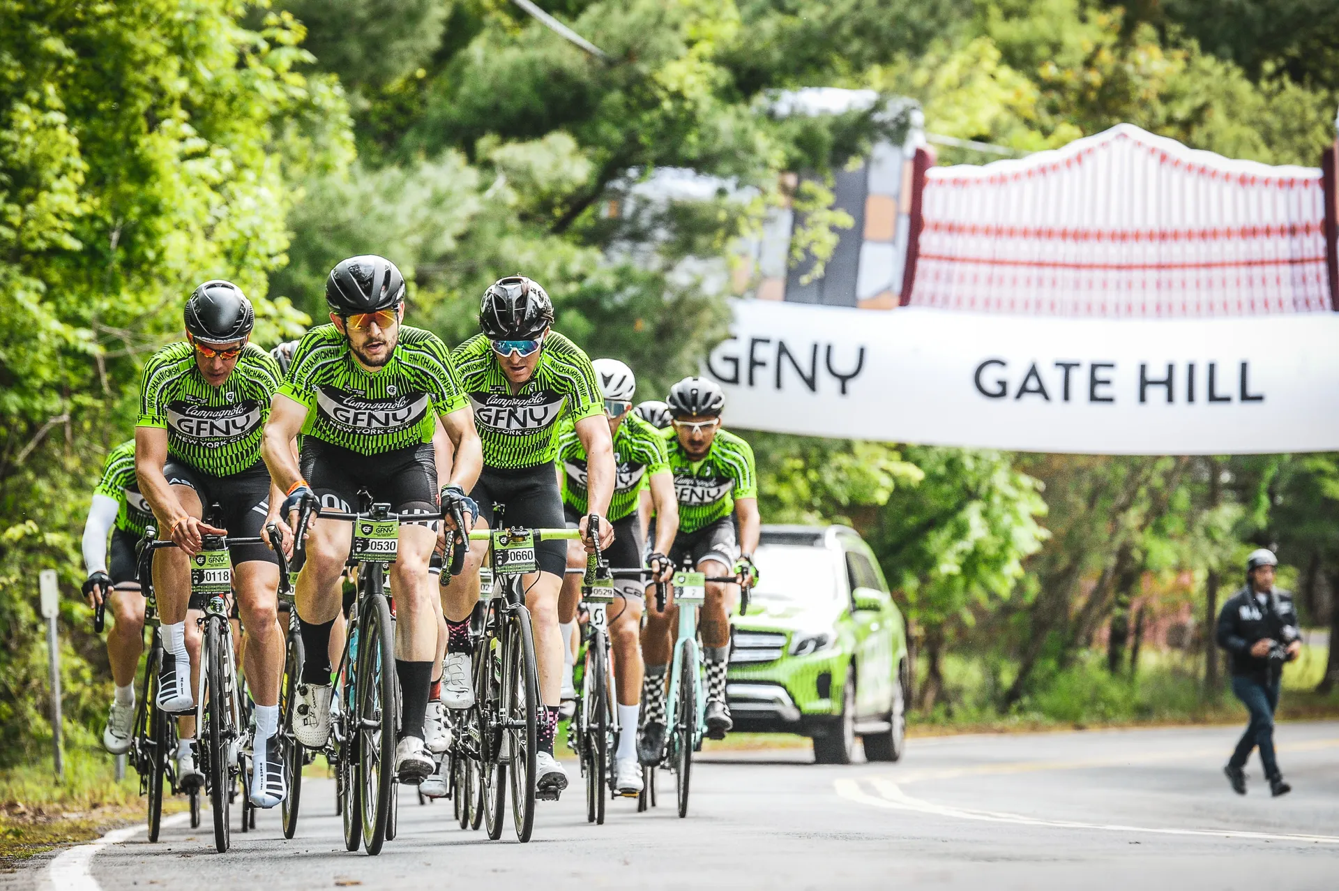 This image shows a group of cyclists riding closely together on a road, likely participating