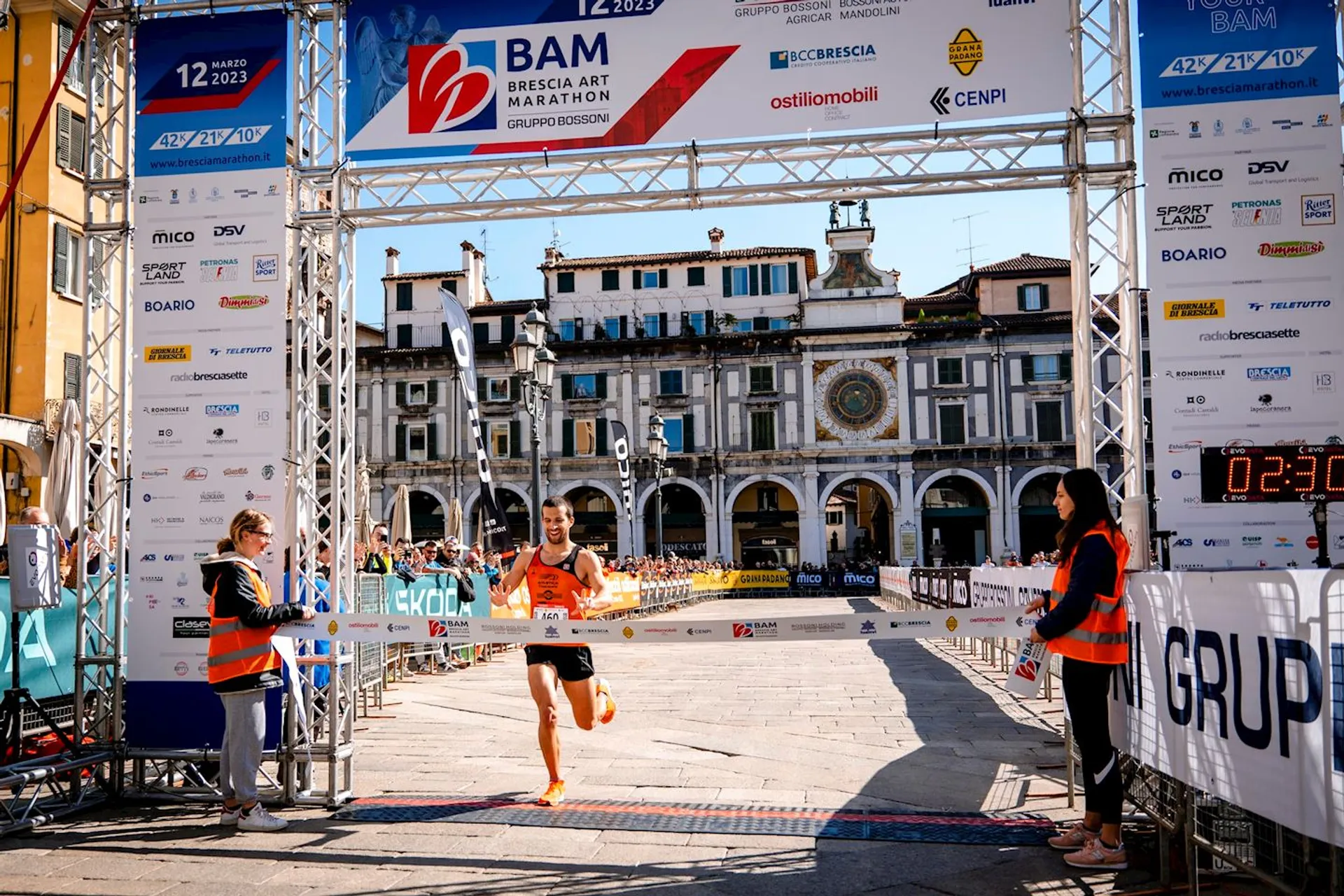 In the image, there is a runner crossing the finish line at what appears to