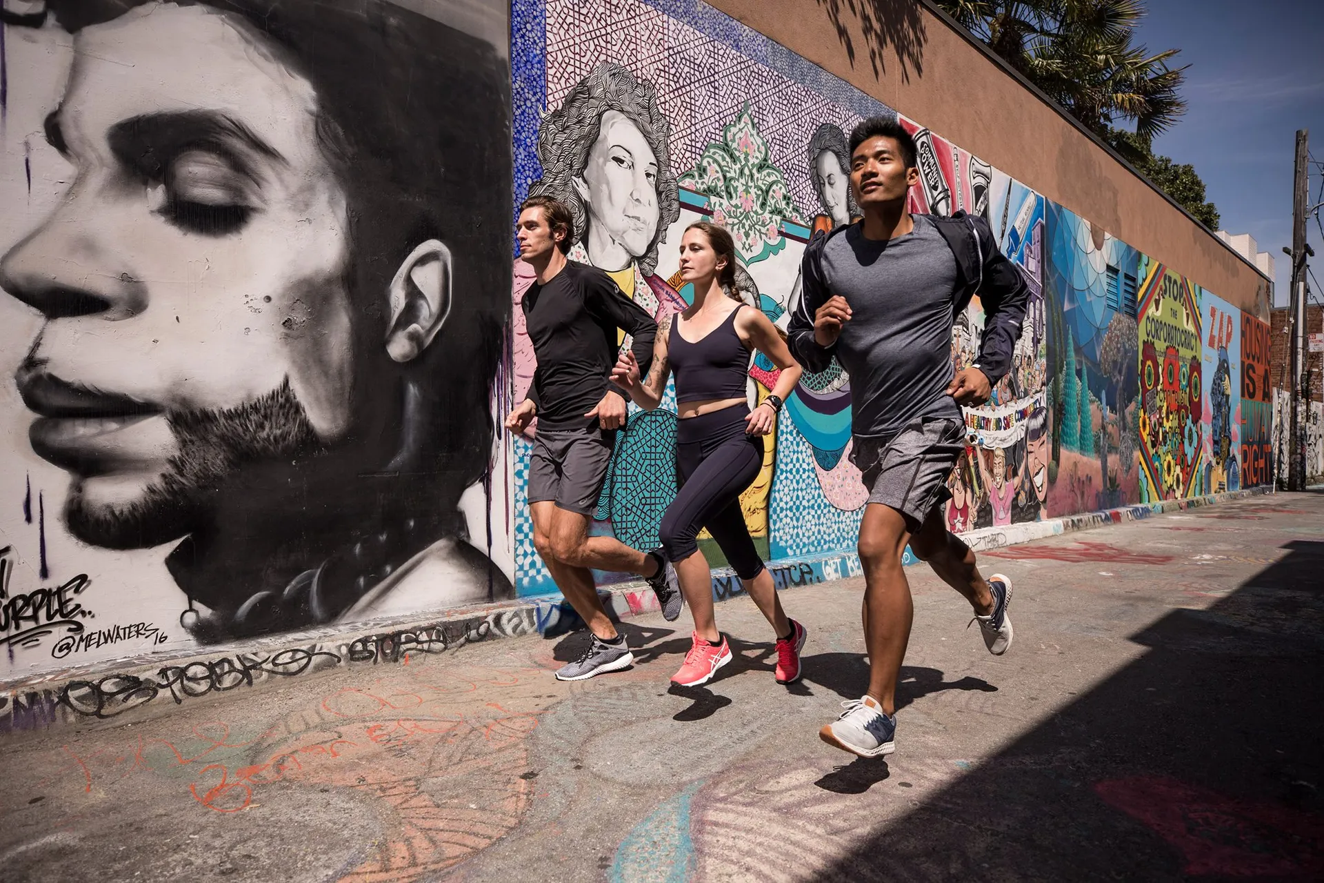 In the image, you can see three people jogging along a street. They are