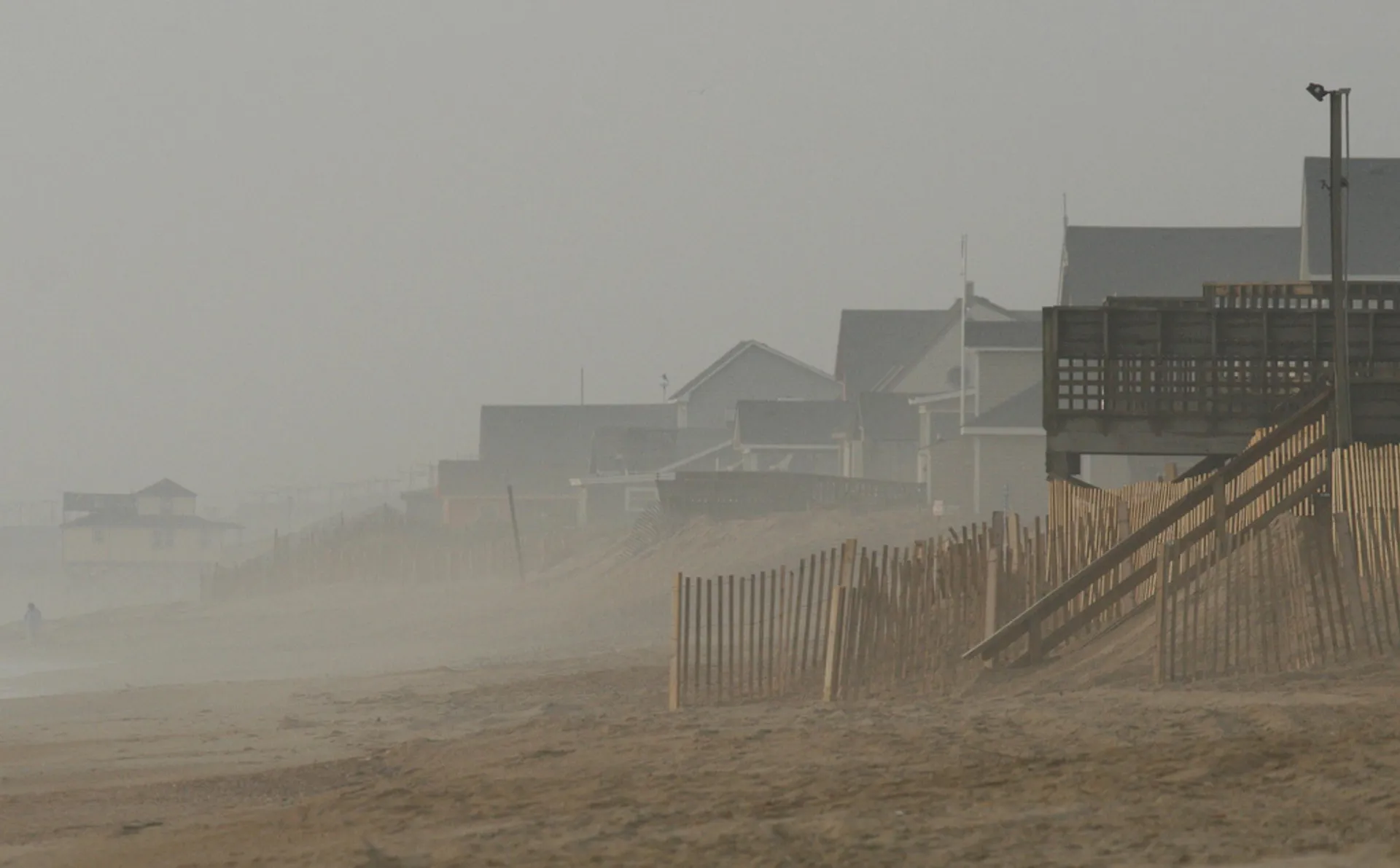 The image depicts a sandy beach on what appears to be a foggy or mist
