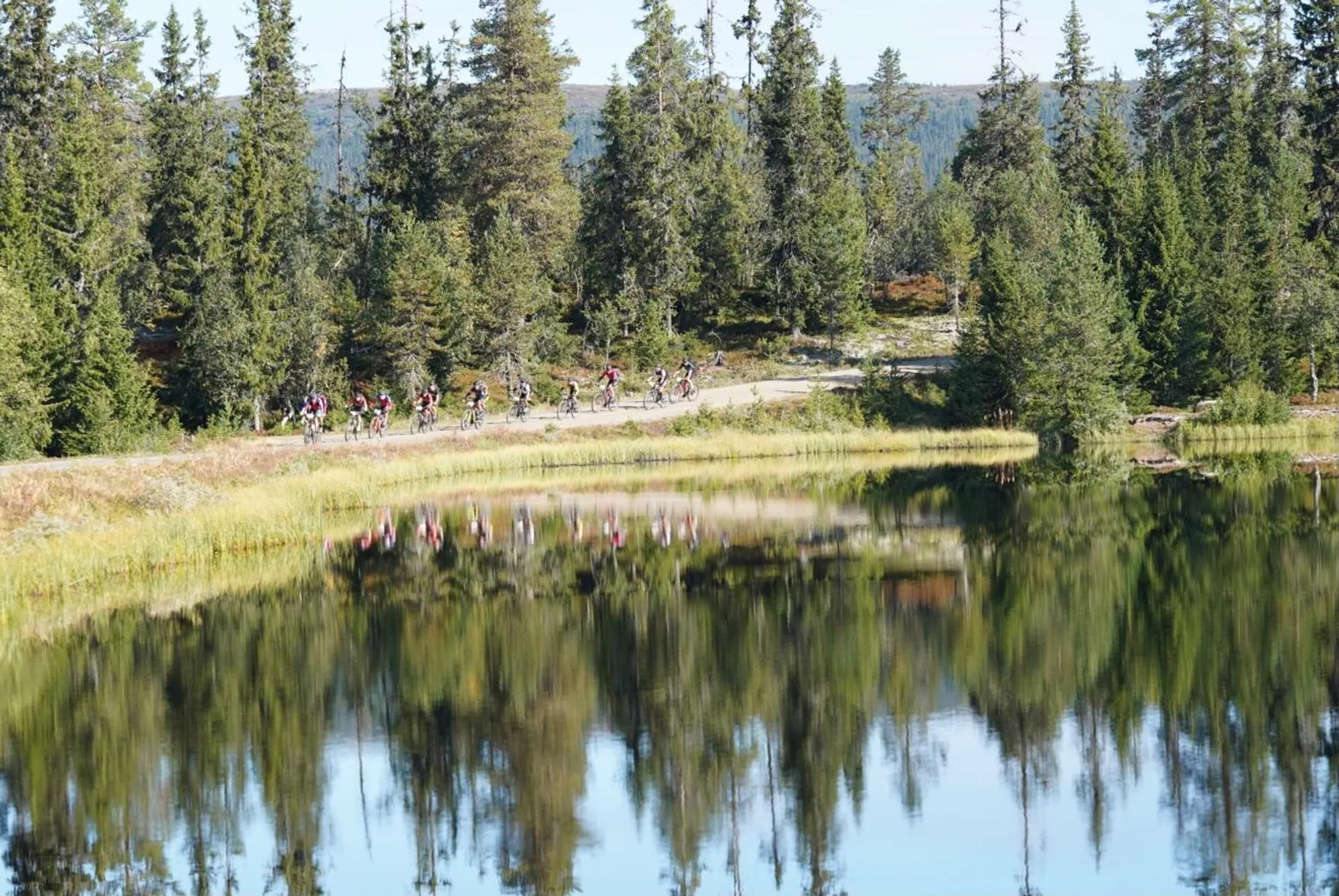 The image depicts a serene natural landscape with a calm body of water in the foreground