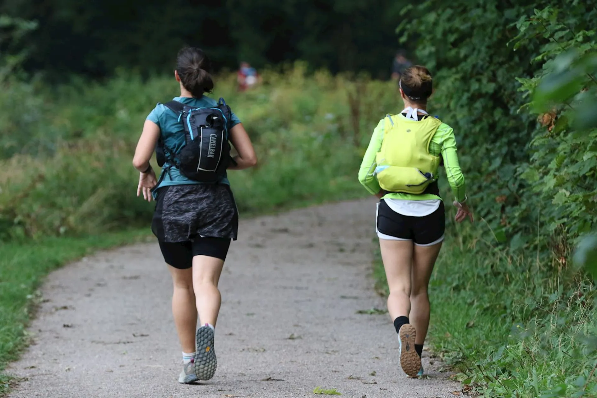 The image shows two individuals jogging on a path. The path appears to be surrounded