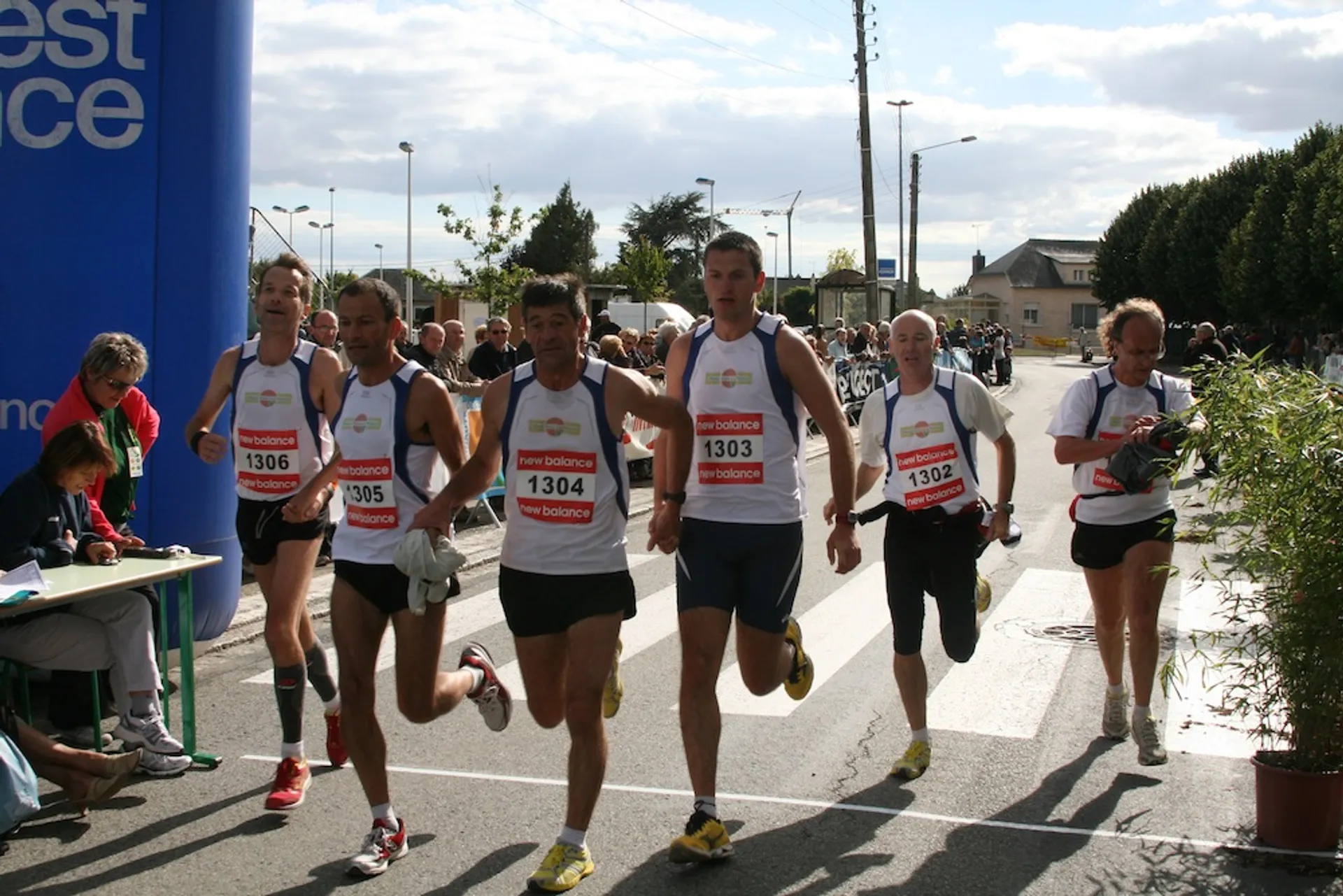 The image depicts a group of runners participating in a road race. They are wearing