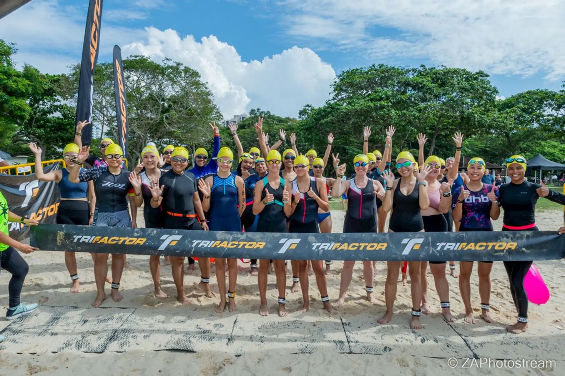 In the image, you see a group of individuals on a sandy beach, likely