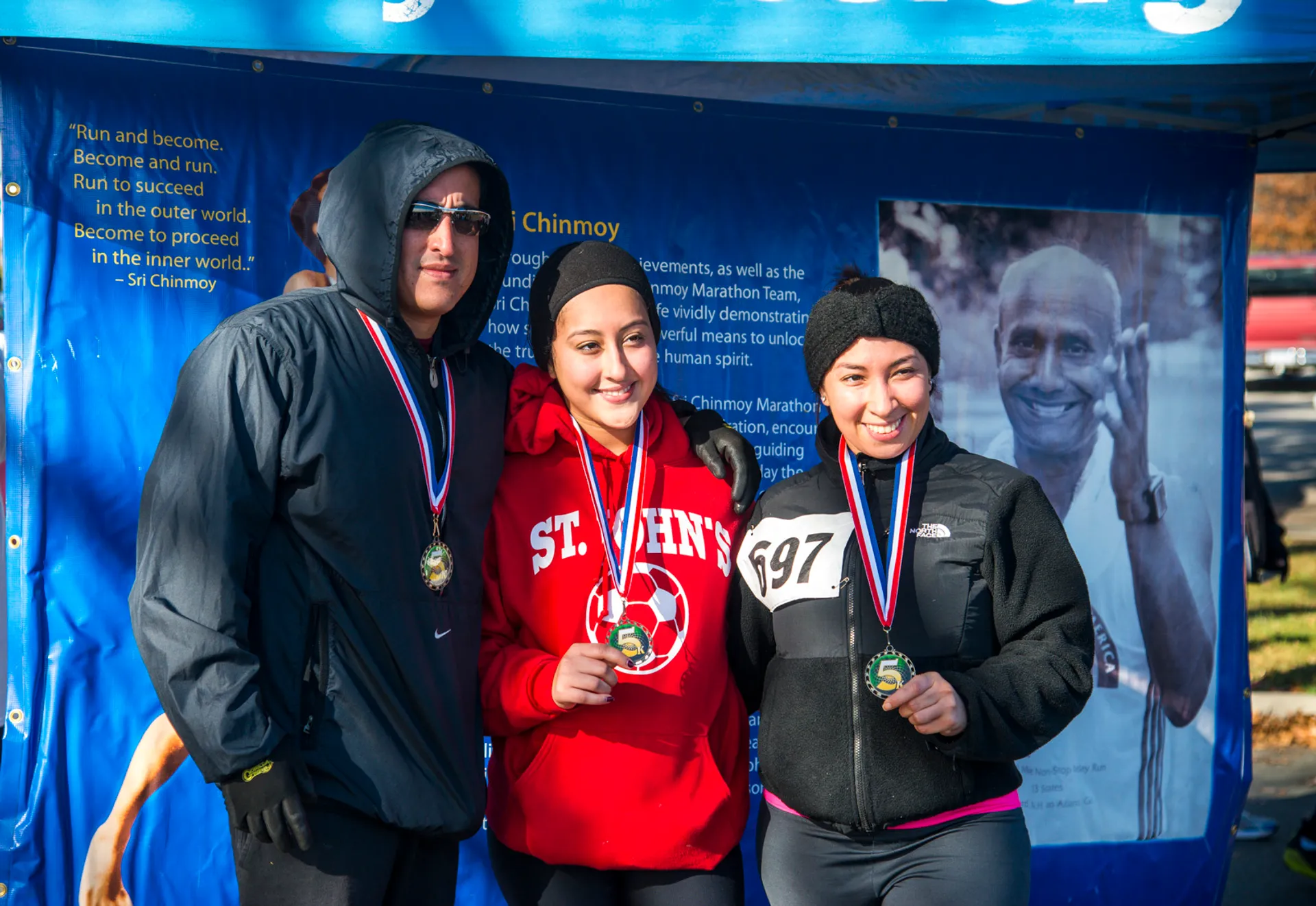 The image shows three individuals standing together, posing for a photograph, seemingly after participating
