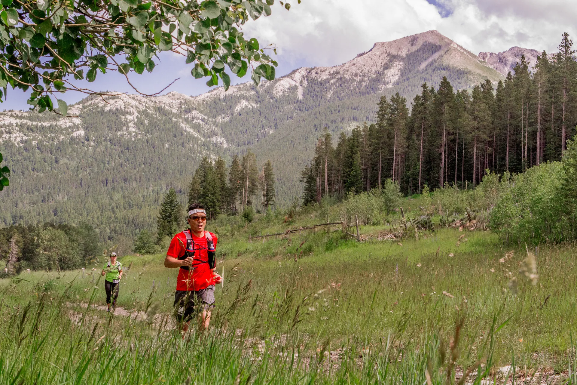 In this image, there are two individuals trail running in a scenic, natural setting
