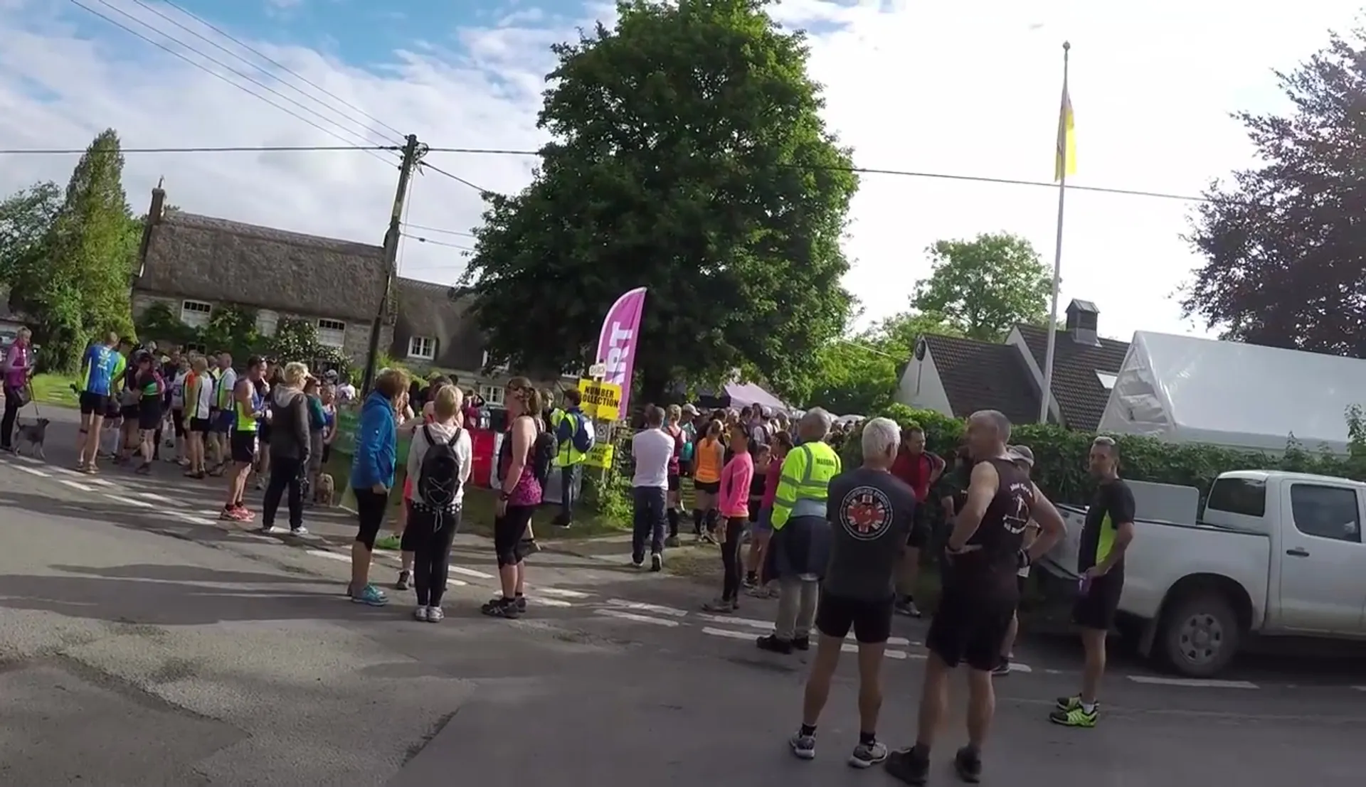 The image shows a group of people gathered on a street, most likely participants in