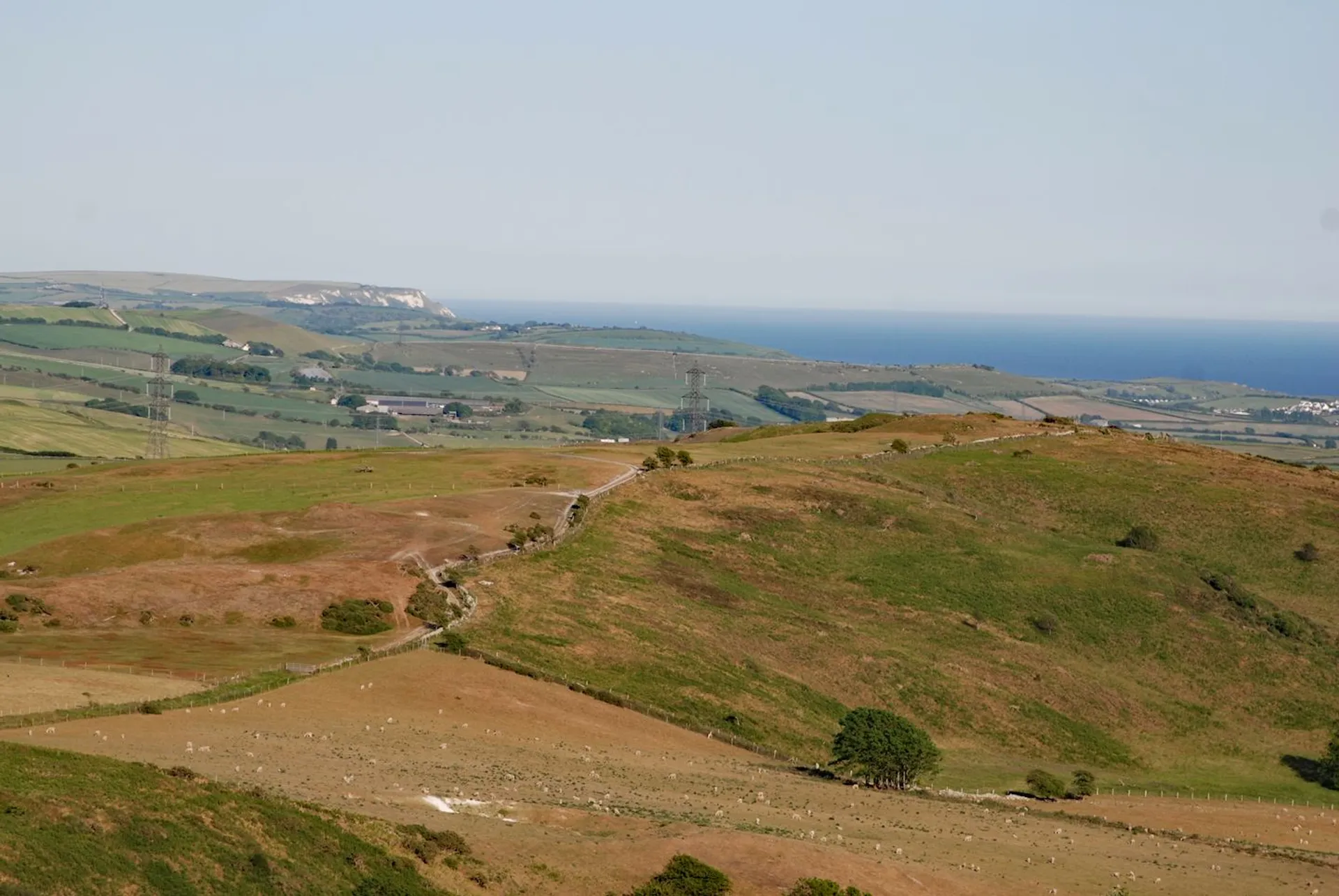 The image shows a scenic landscape with rolling hills. There are open grassy areas