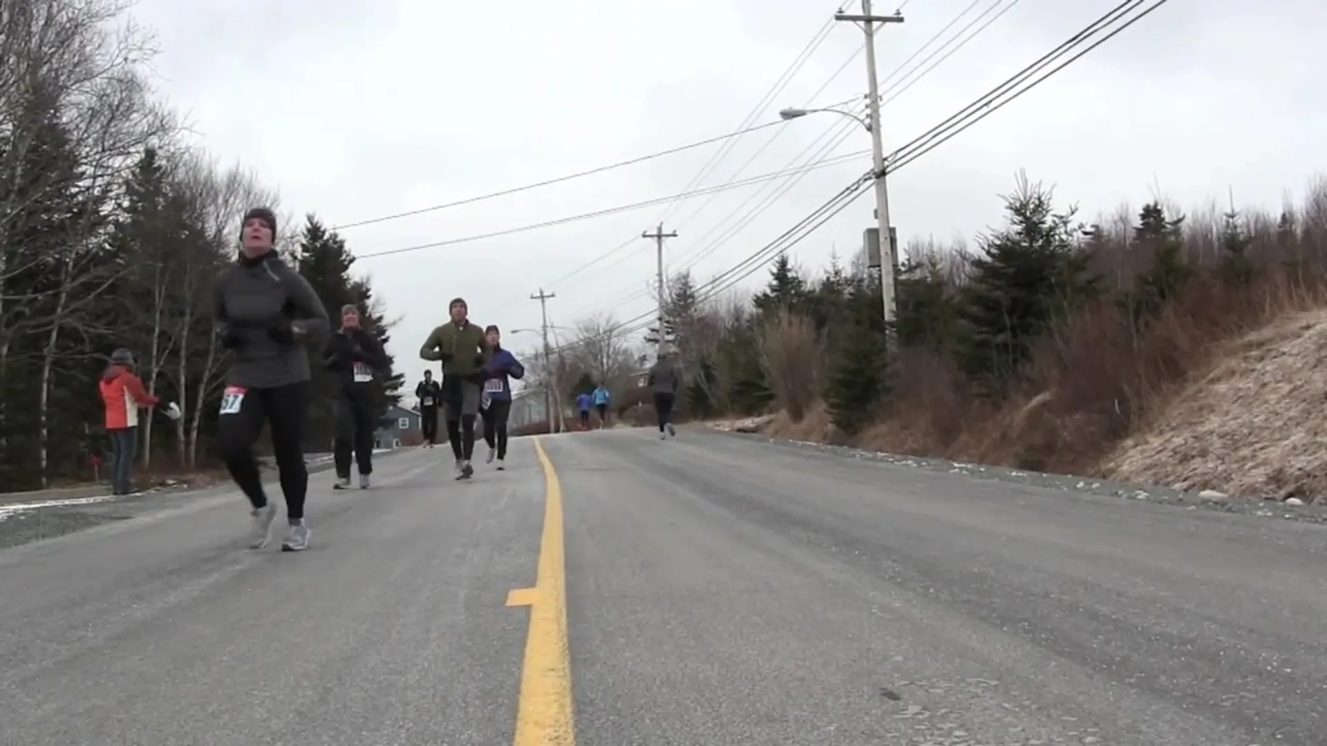The image shows a group of people running on a road. They appear to be