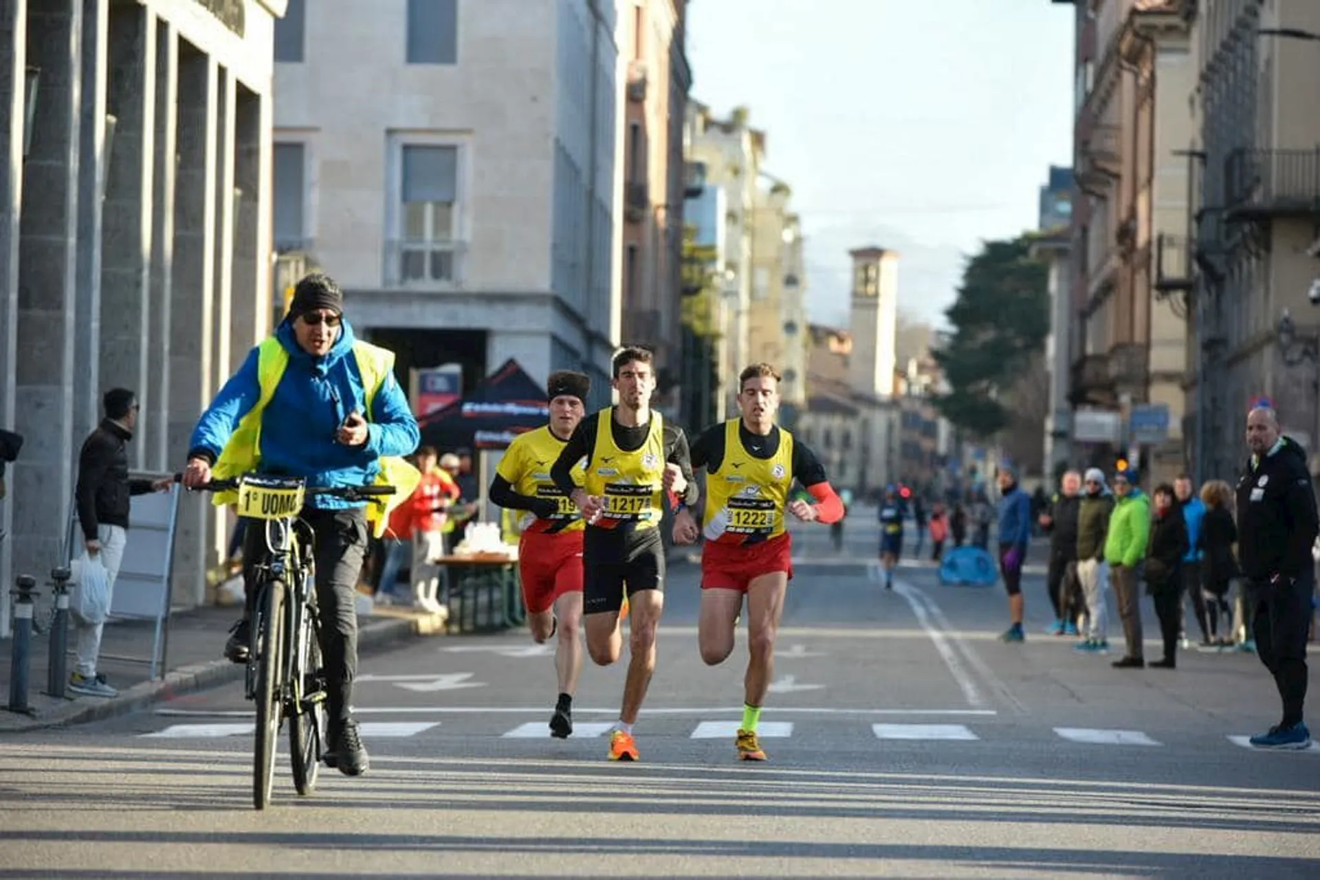 The image shows a street scene with what appears to be a road race in progress