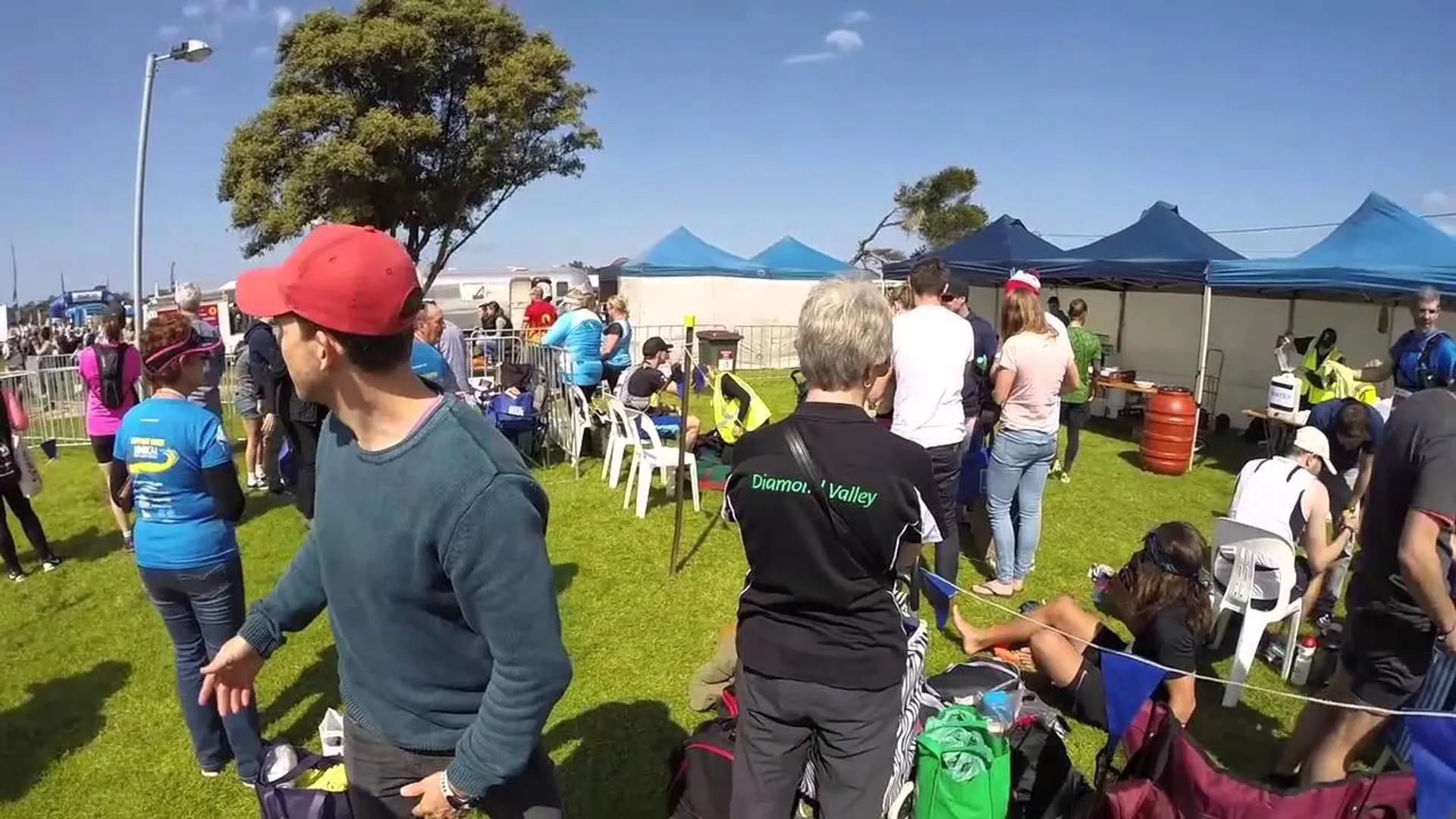 The image shows an outdoor event on a sunny day with clear blue skies. There