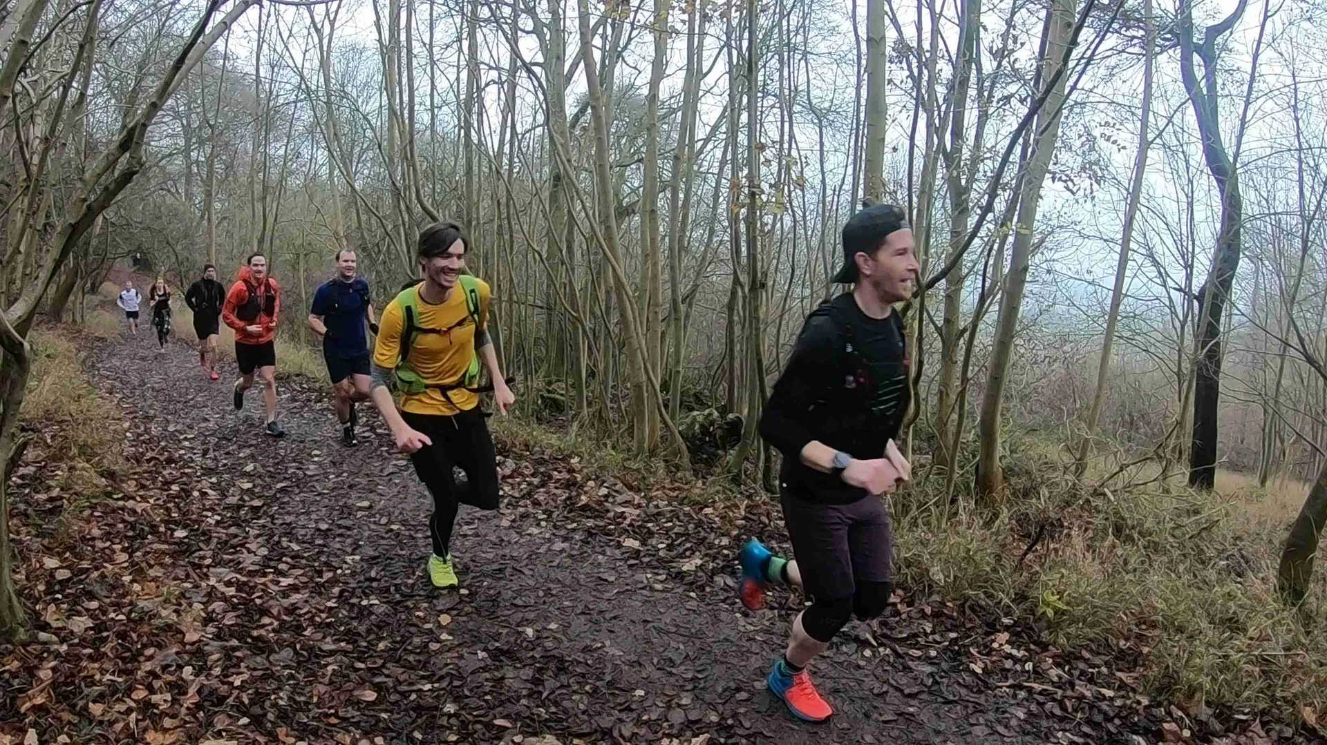 The image depicts a group of people engaging in an outdoor running activity on a trail